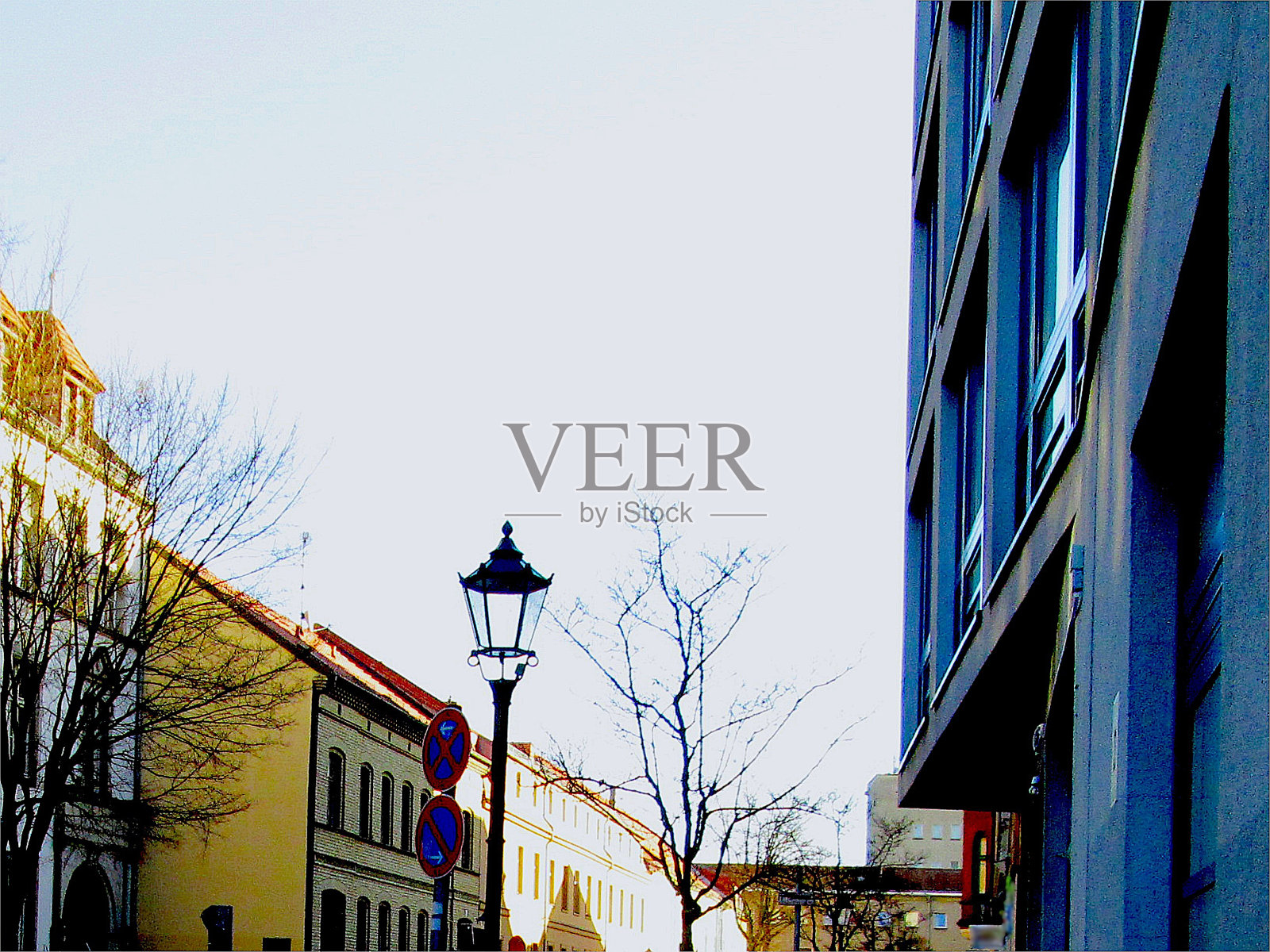 柏林Koepenick老城阳光街旧建筑粗糙的光秃秃的树木和路灯照片摄影图片