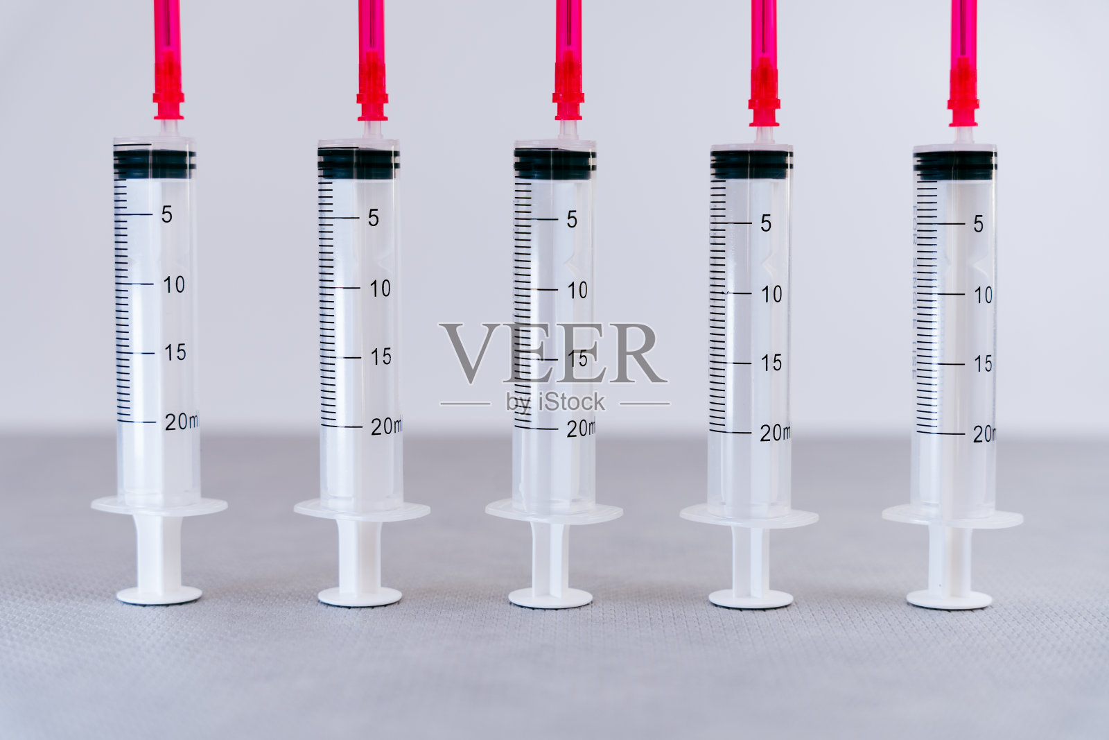 在无菌和医疗空间内放置一排注射器和相应的针头照片摄影图片