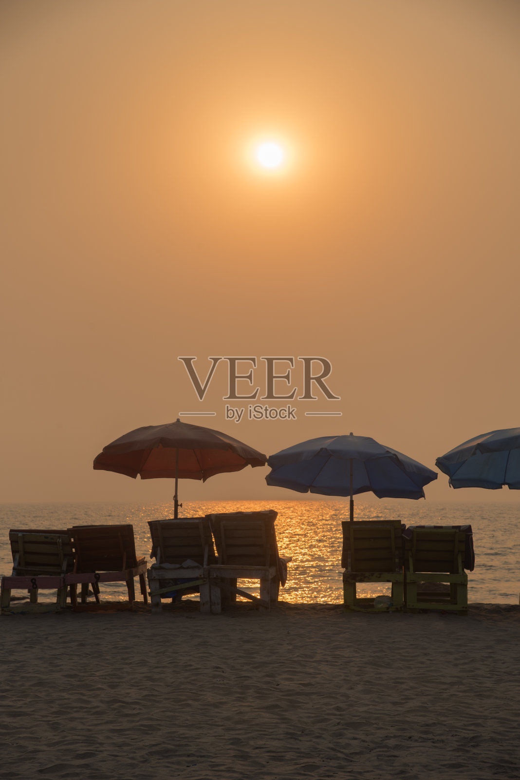 在果阿邦的Arambhol海滩,沙滩椅和遮阳伞与日落。照片摄影图片