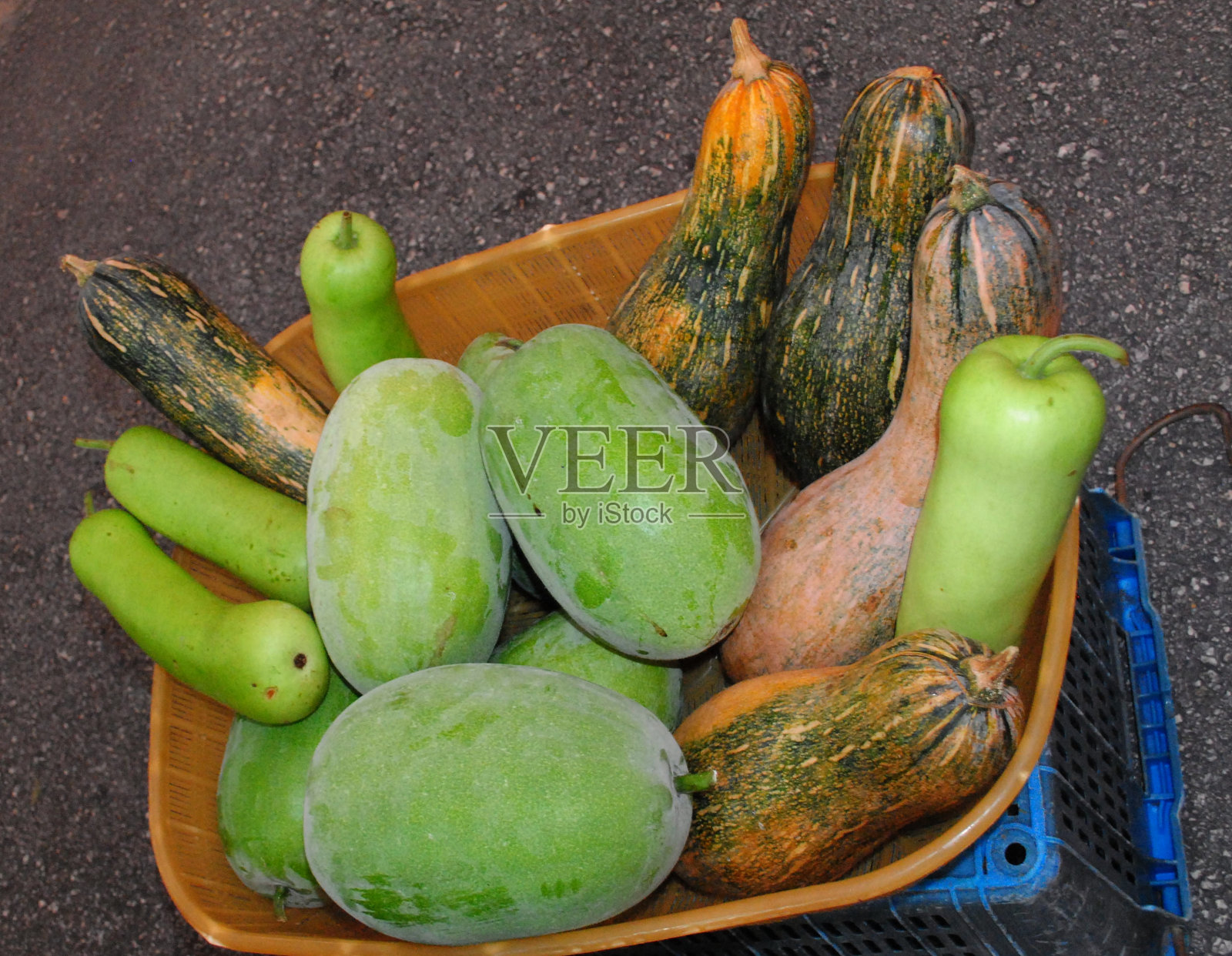 南瓜和西葫芦放在地上的篮子里照片摄影图片