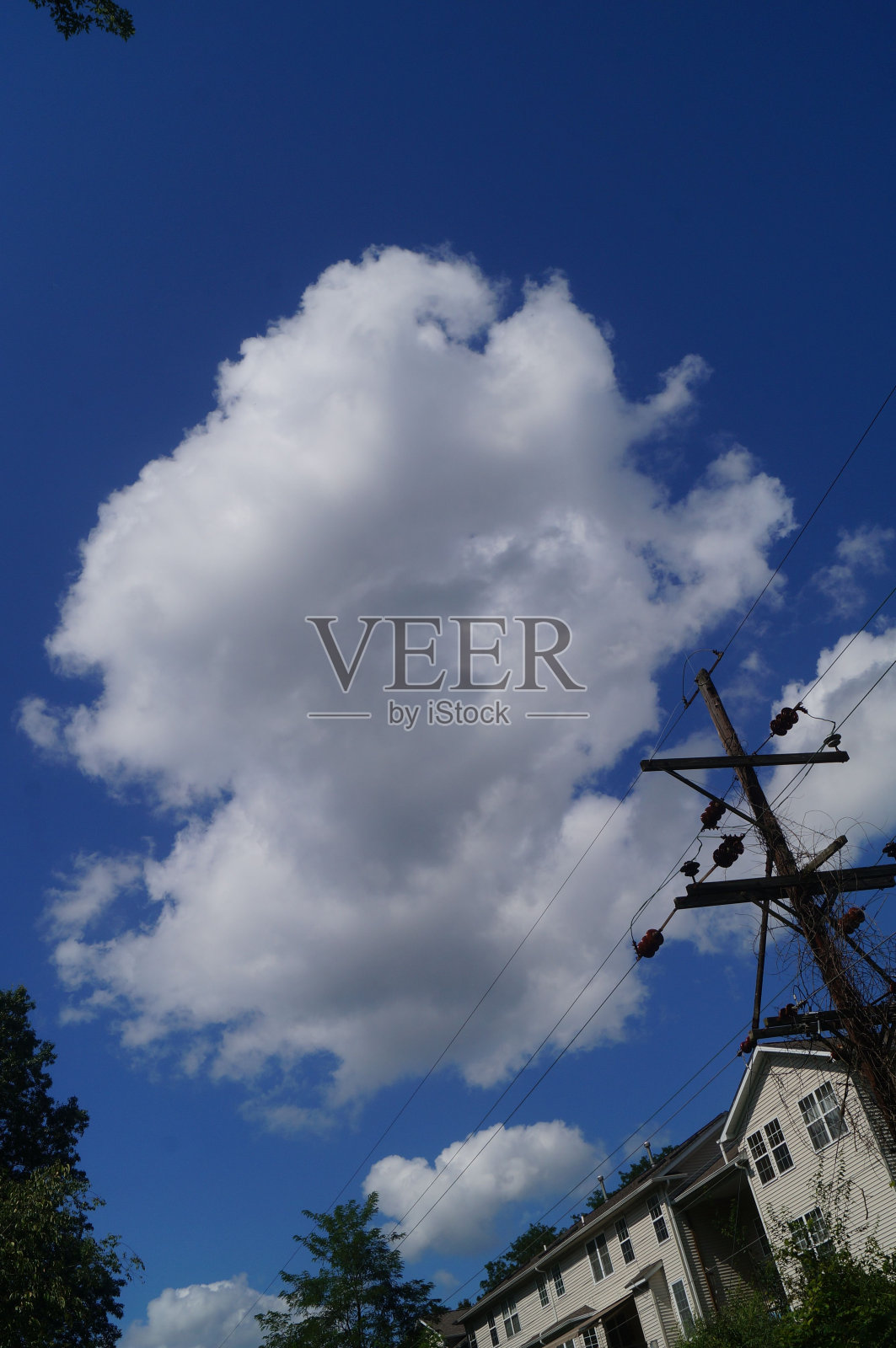 美丽的白云在阳光明媚的蓝天上飞过房屋照片摄影图片