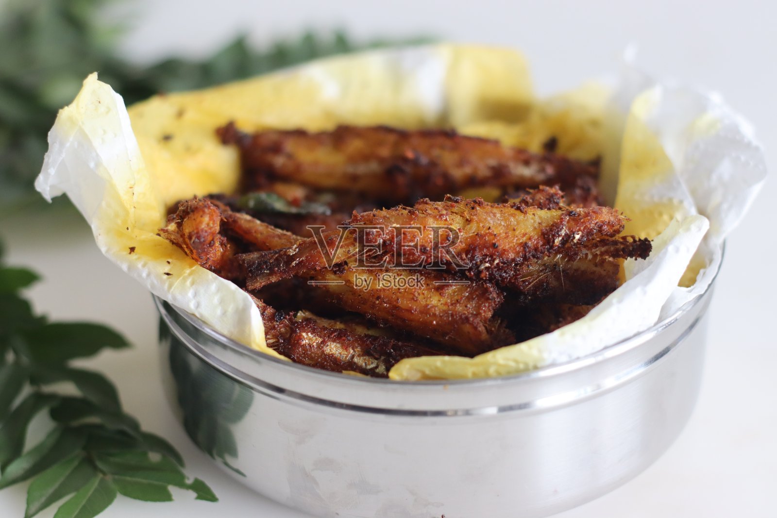 美味的凤尾鱼煎炸,酥脆金黄,配上配菜上桌照片摄影图片