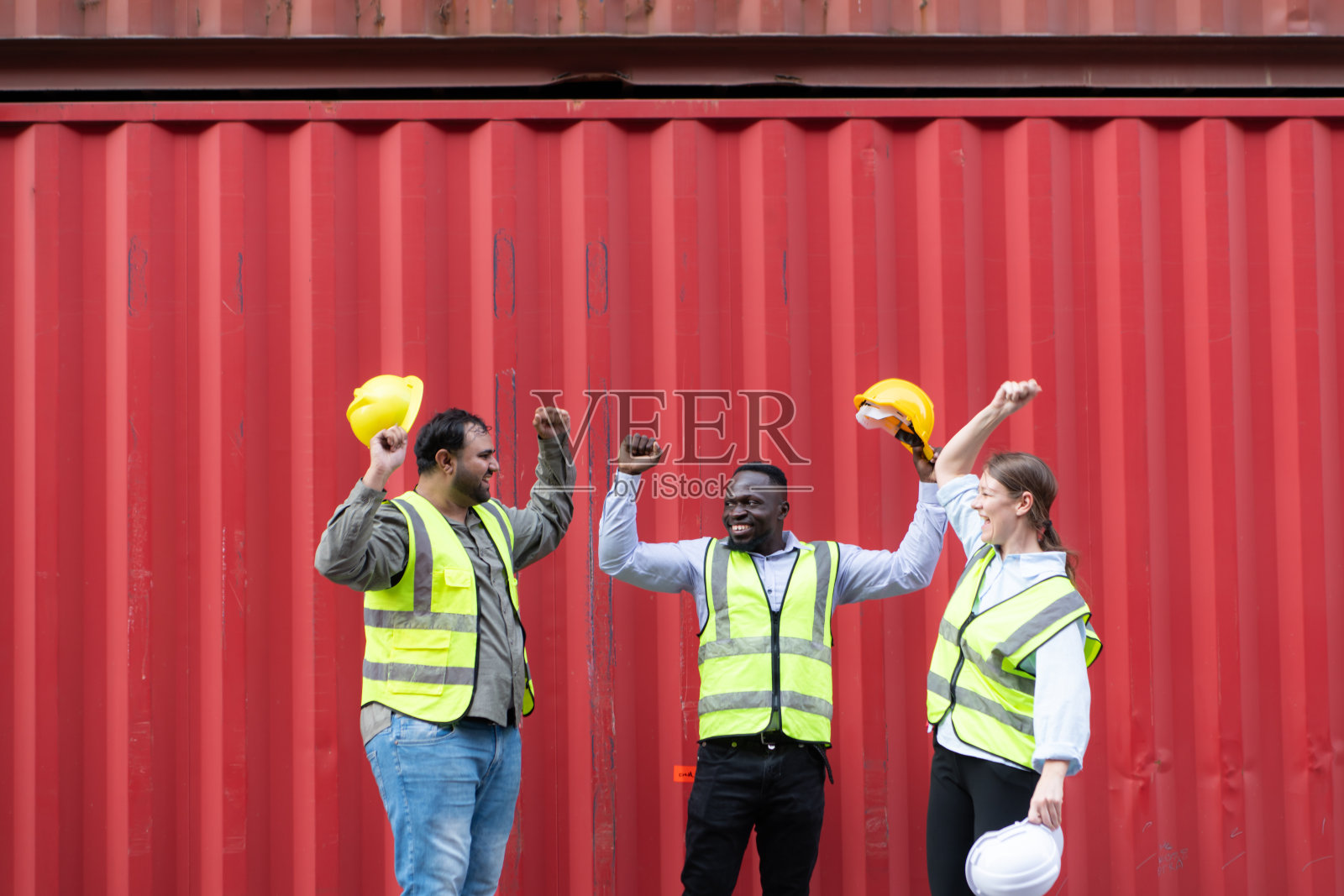 一群集装箱堆场工人在集装箱仓库前休息时互相问候。照片摄影图片