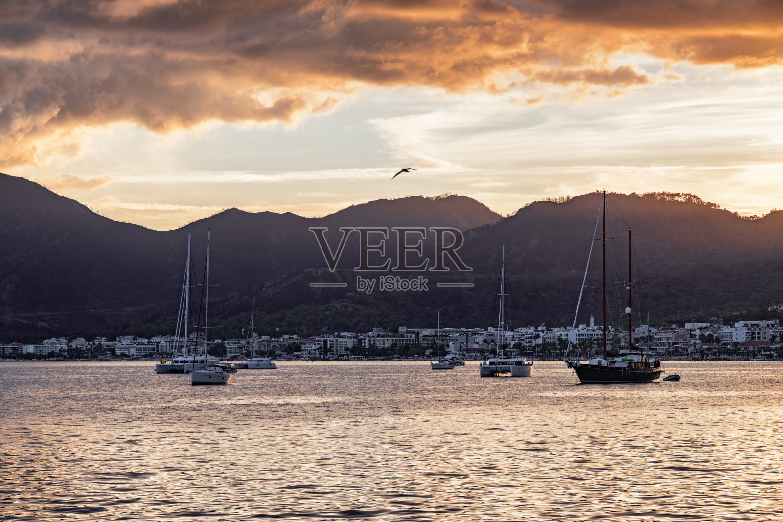 日落的游艇穿过马尔马里斯港,土耳其。照片摄影图片