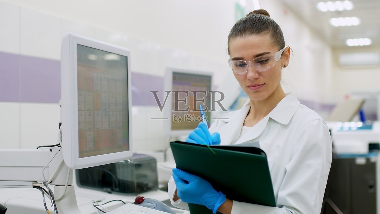 一位女科学家控制着实验室研究设备的操作。现代实验室技术。医学研究用离心机。照片摄影图片