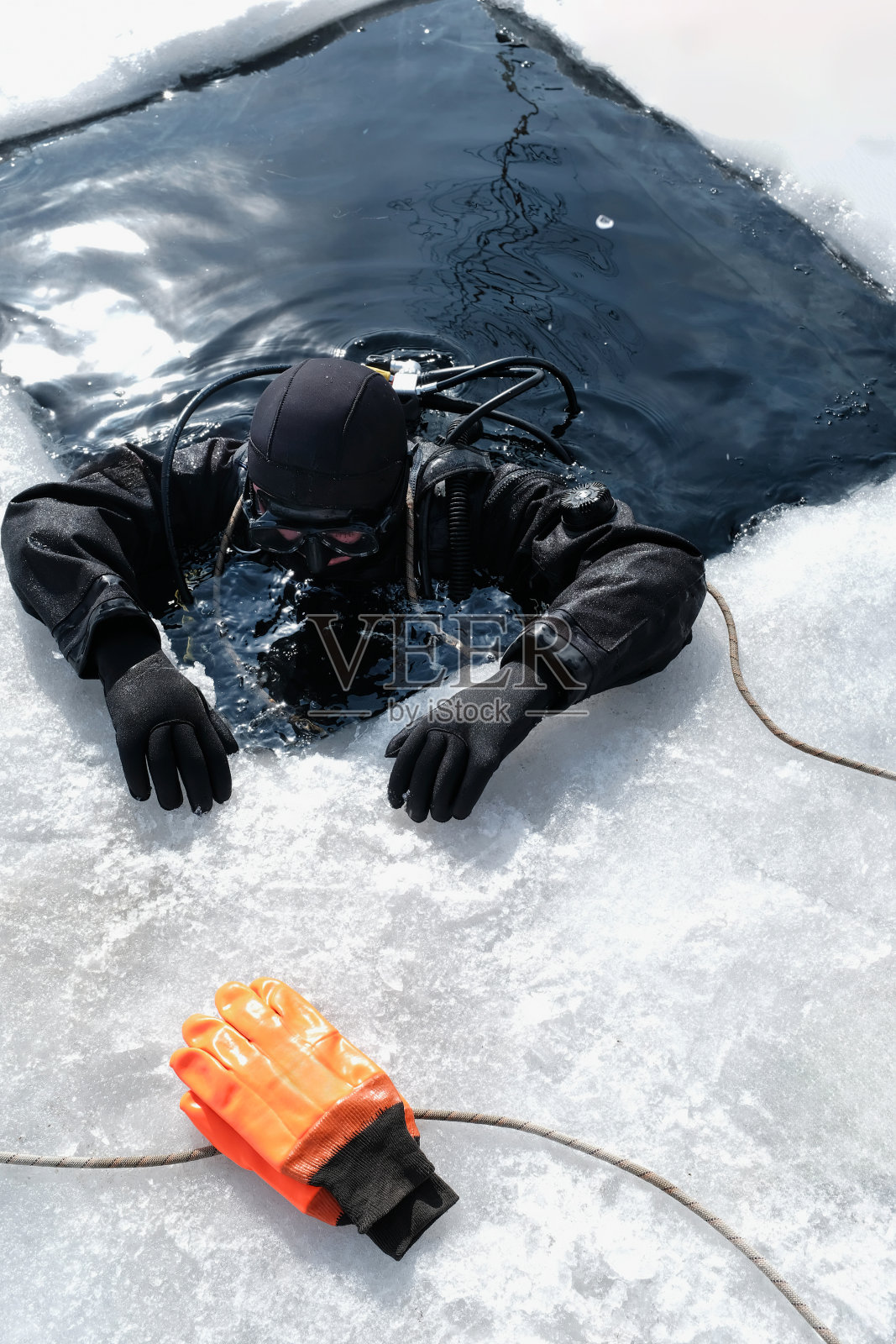 冬天在冰冷的水中游泳的潜水员照片摄影图片