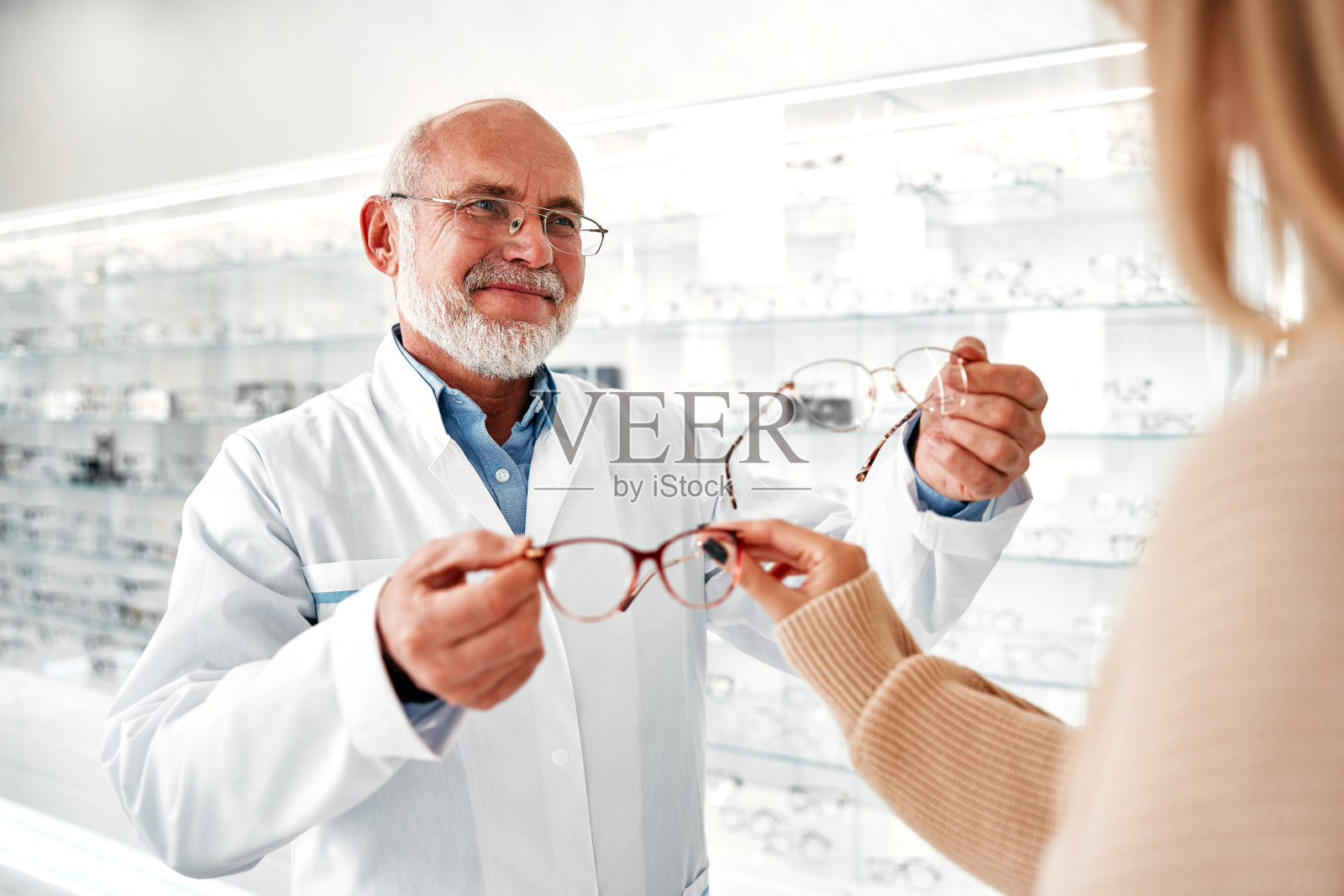 由眼科医生配戴眼镜和检查眼睛照片摄影图片