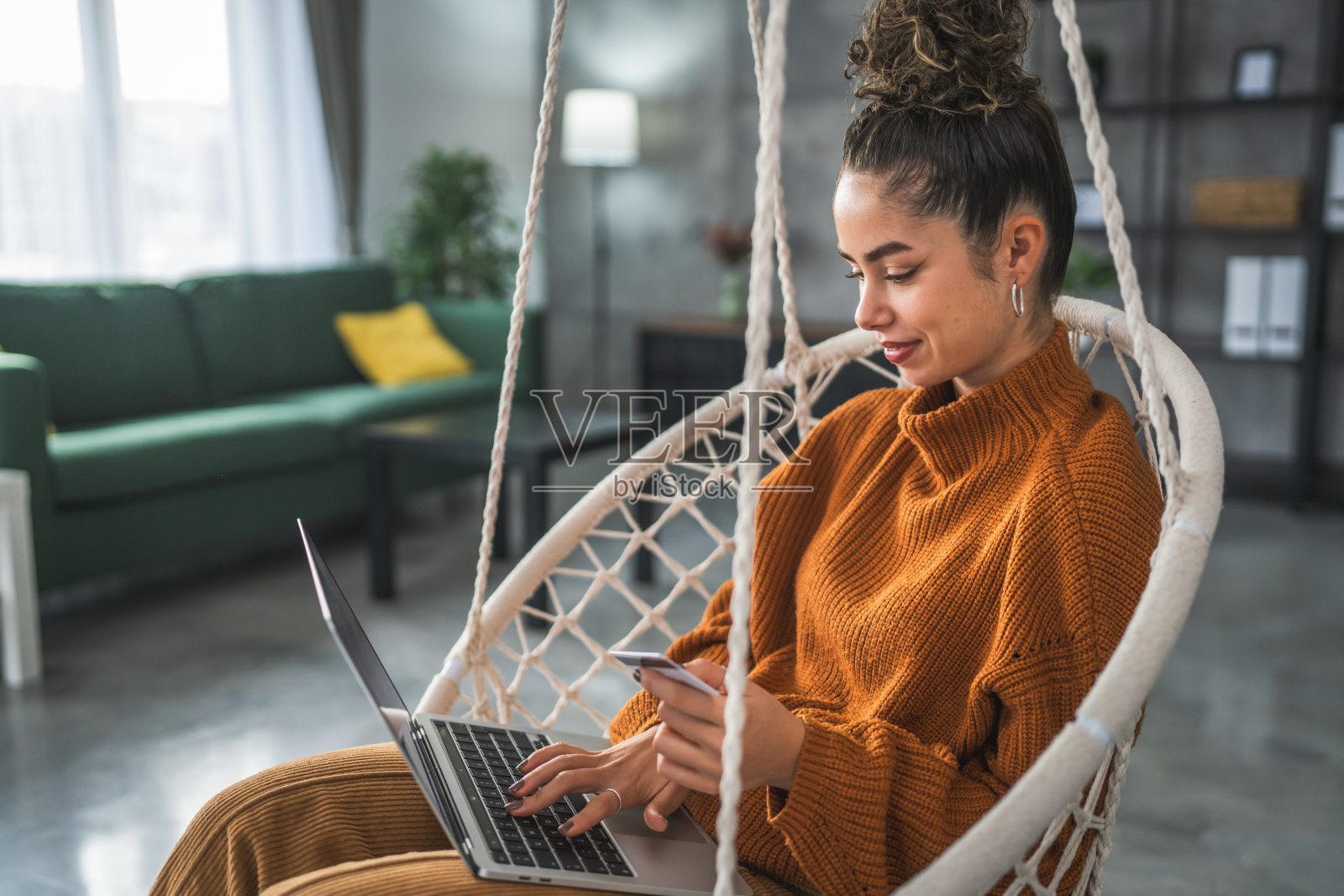 年轻女子白种女性持信用卡在家网上购物照片摄影图片