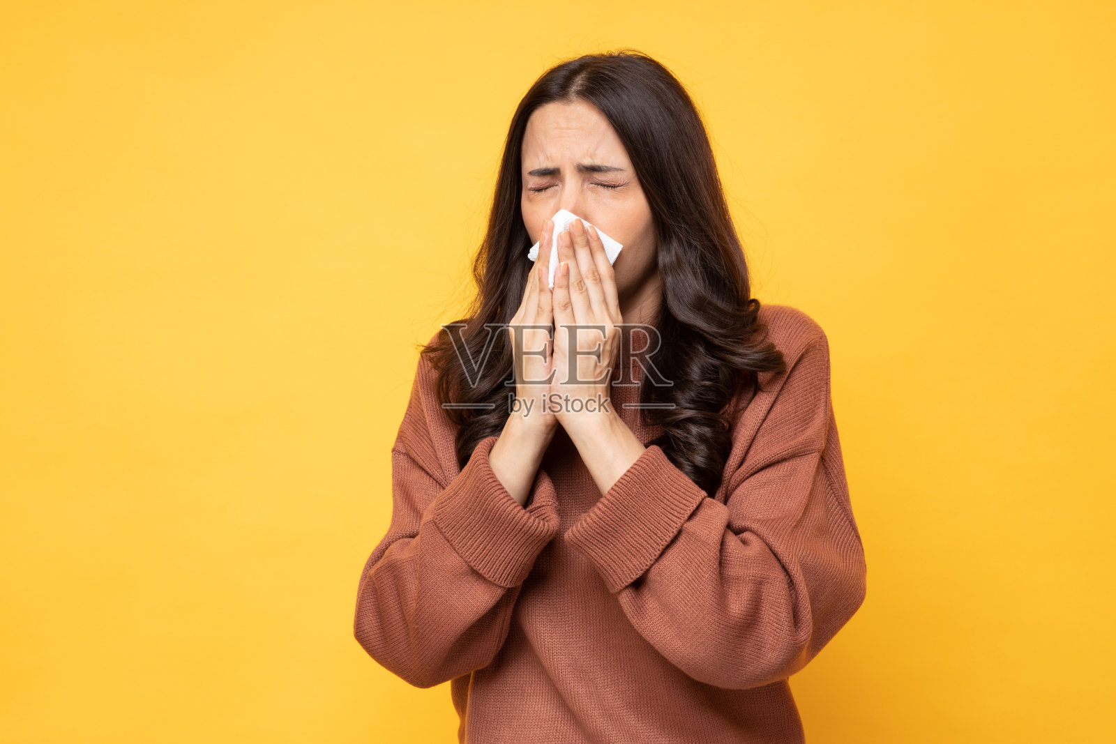 年轻生病的女人有过敏和打喷嚏的组织在黄色背景股票照片照片摄影图片