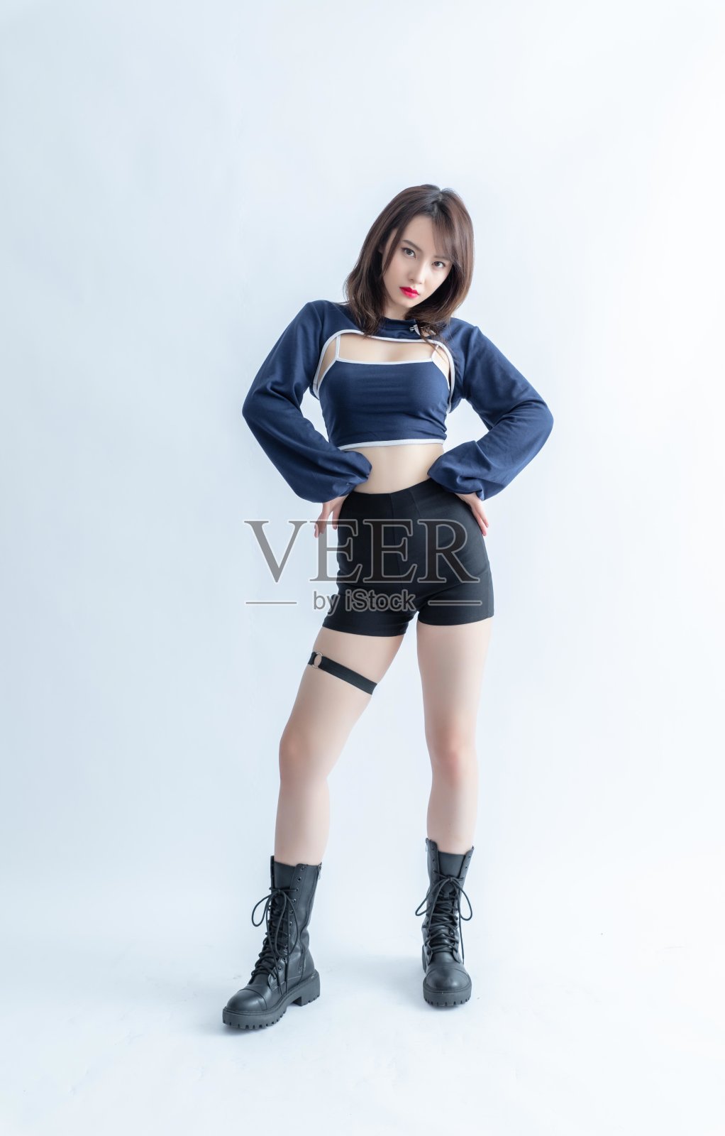 穿着蓝色露脐上衣和黑色短裤的亚洲女人照片摄影图片