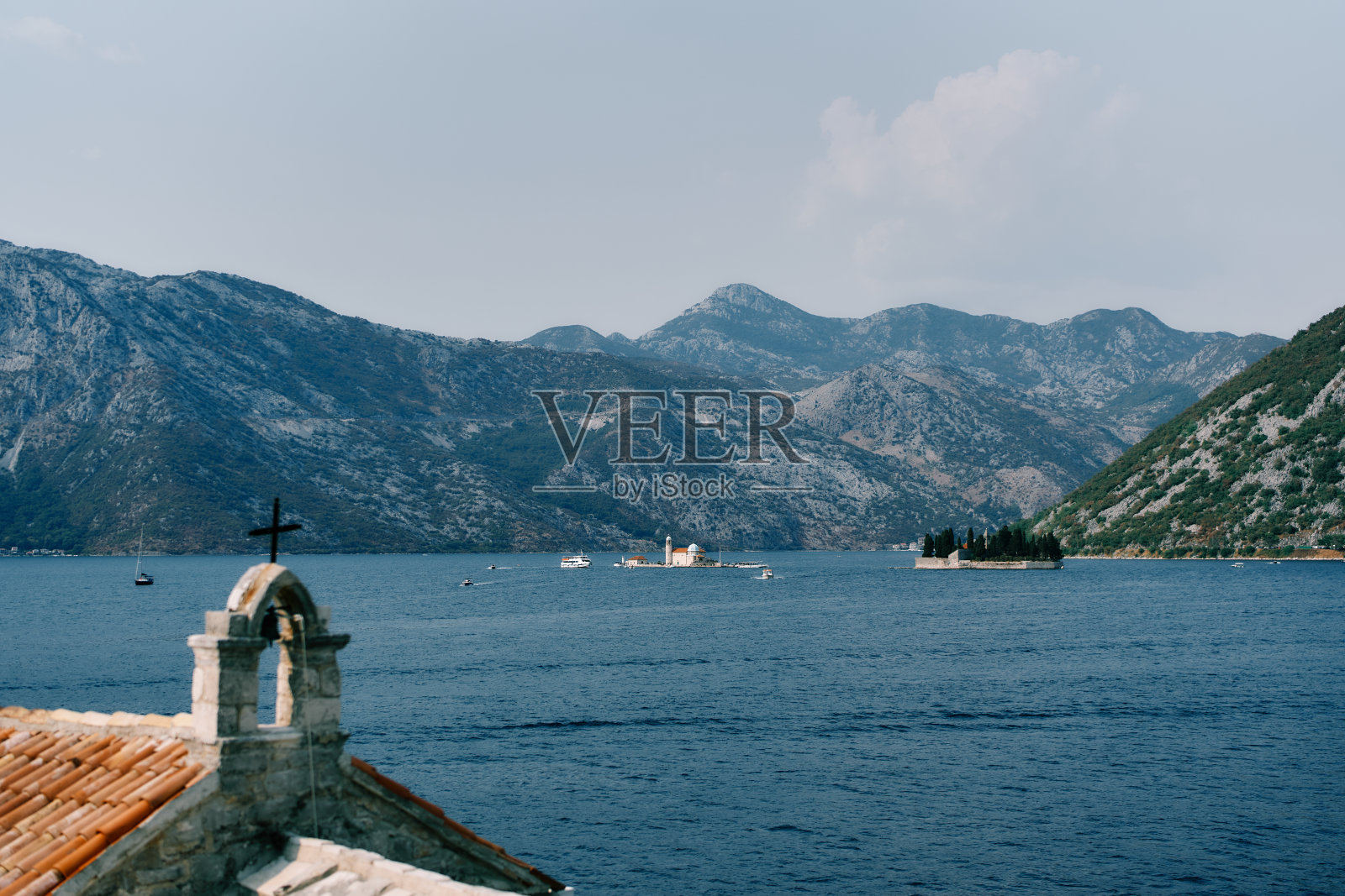 天使圣母教堂屋顶上的小钟楼,背景是圣乔治岛。黑山共和国照片摄影图片