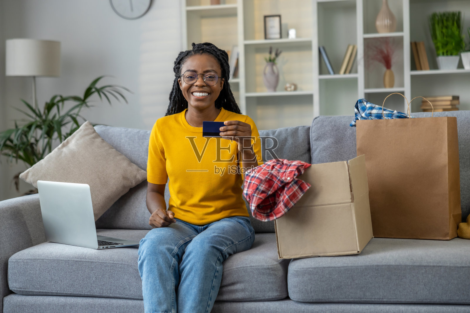 年轻微笑的女人在网上支付时看起来很开心照片摄影图片