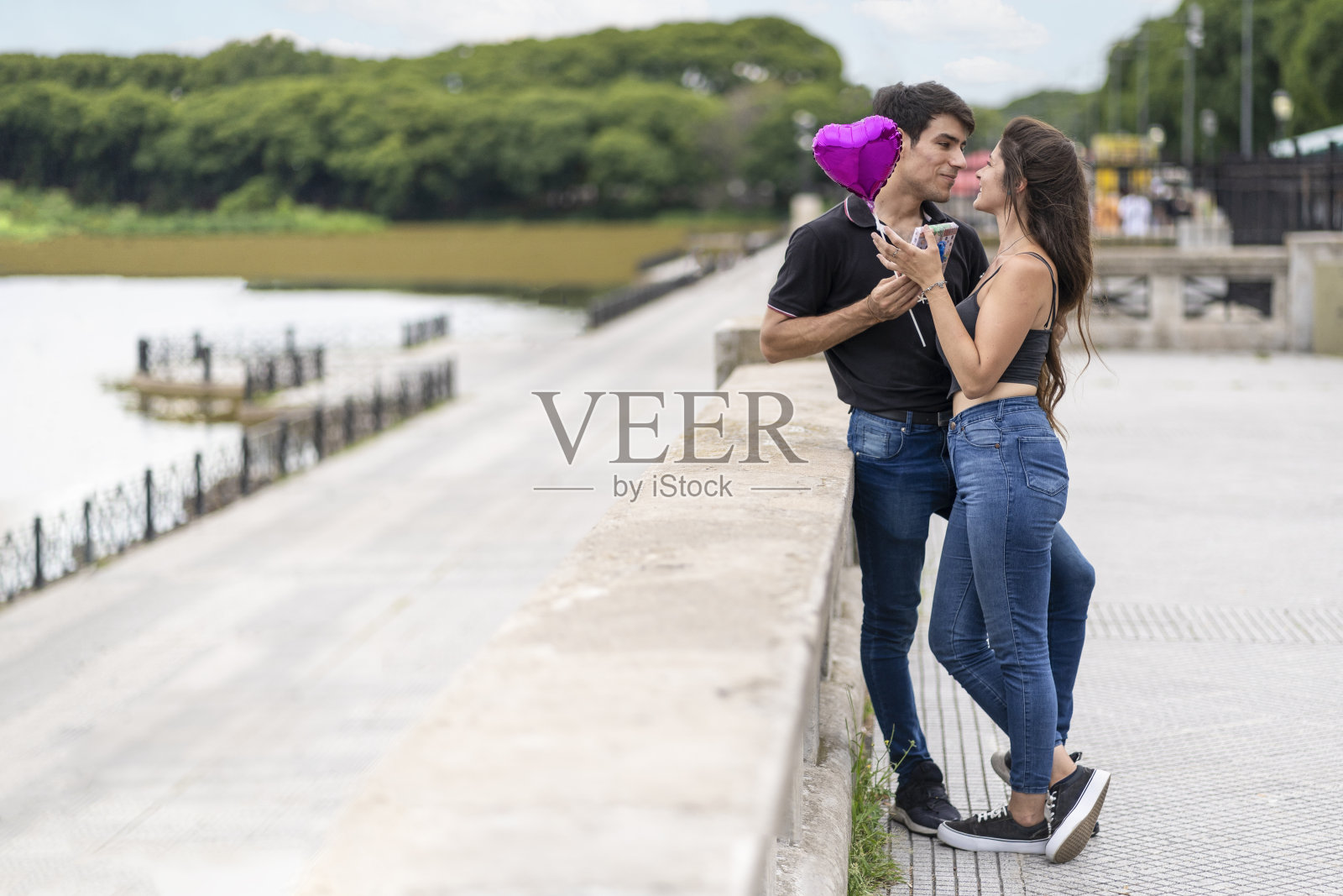 男子用心形气球给女友送礼物。照片摄影图片