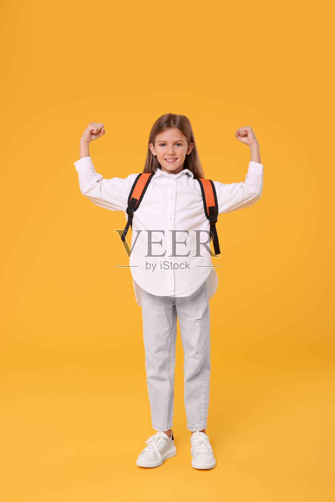 快乐的女学生背着橙色背景的双肩包照片摄影图片