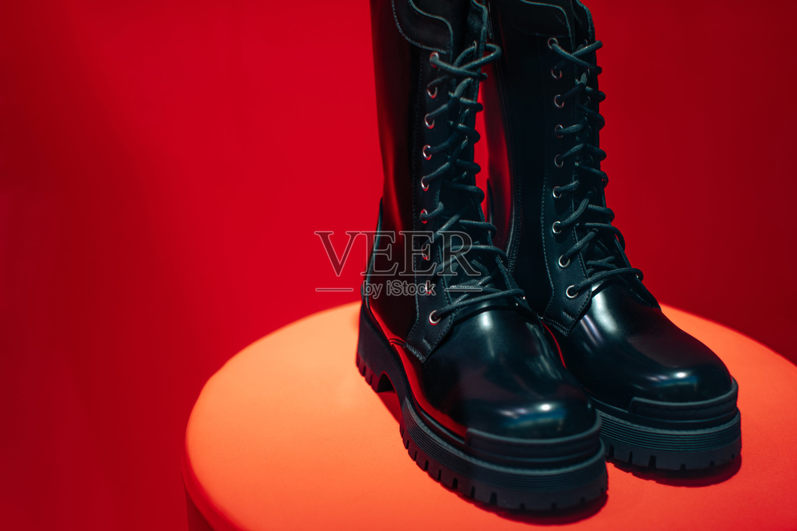 黑色女性漆皮系带鞋在精品店站在红色背景照片摄影图片