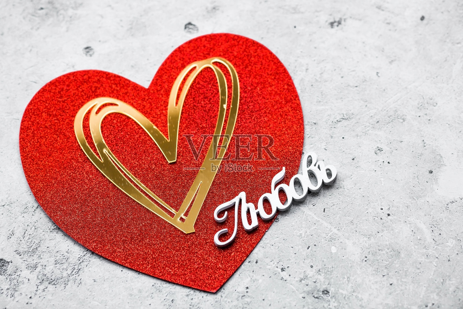 节日背景,红色和金色的心和俄语单词:“爱”在灰色的混凝土背景。从上面看。情人节。照片摄影图片
