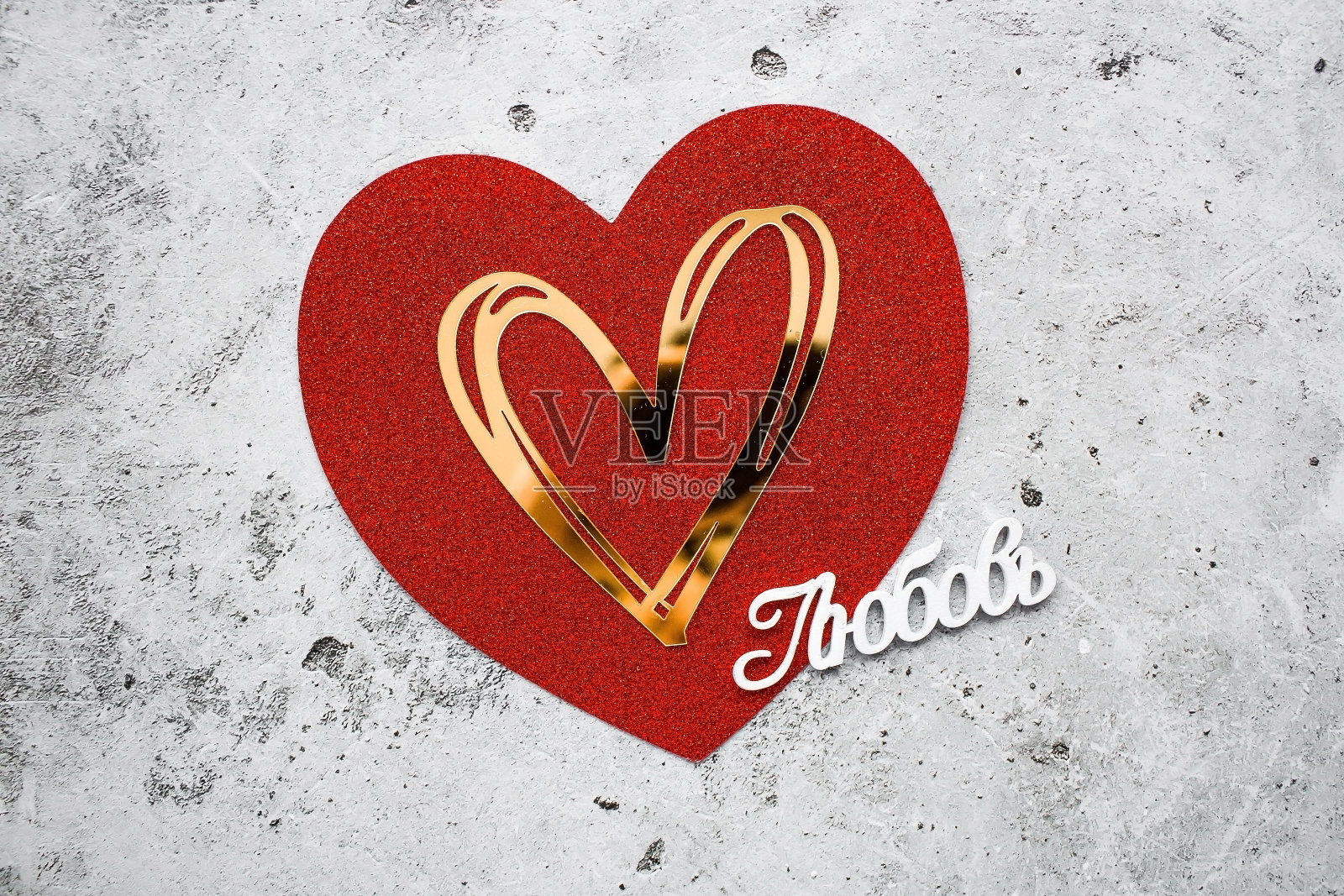节日背景,红色和金色的心和俄语单词:“爱”在灰色的混凝土背景。从上面看。情人节。照片摄影图片