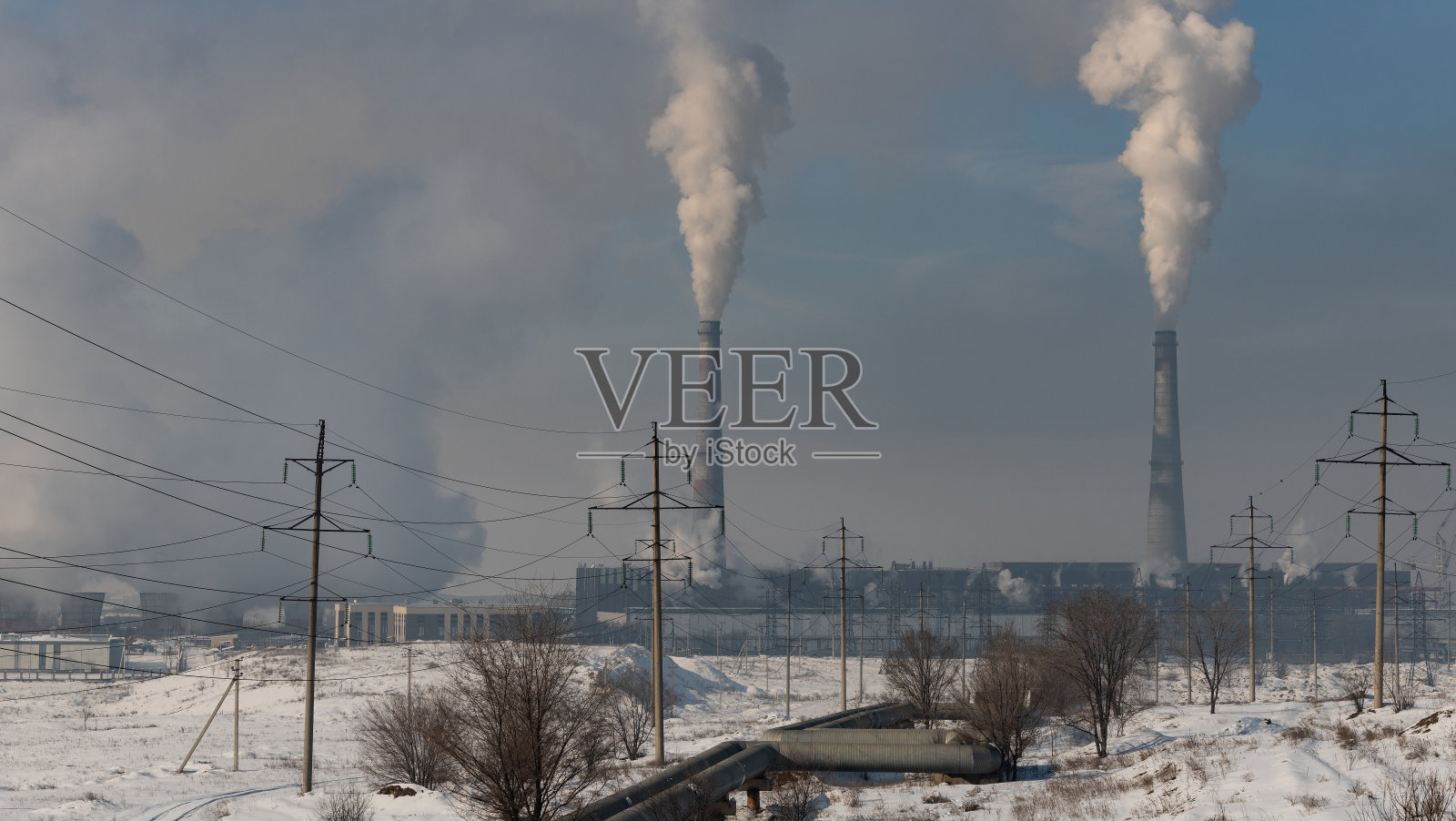 冬天冒烟的燃煤电厂和高压输电线路照片摄影图片