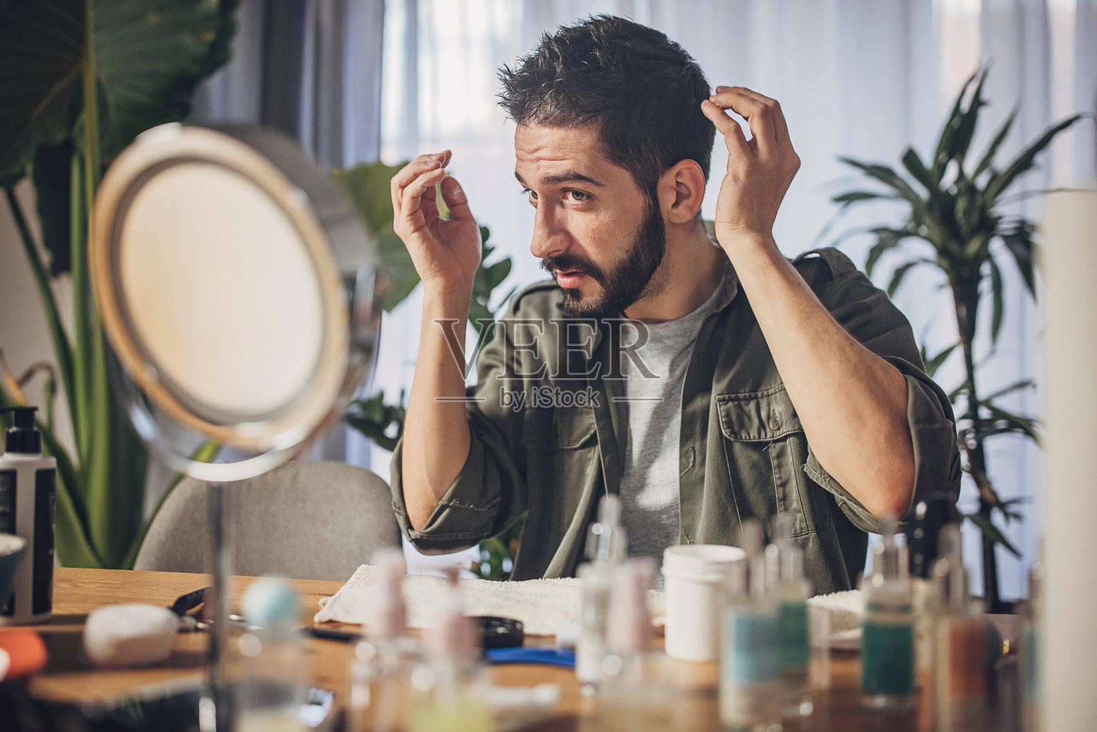 男人在家里造型他的头发并涂发胶照片摄影图片
