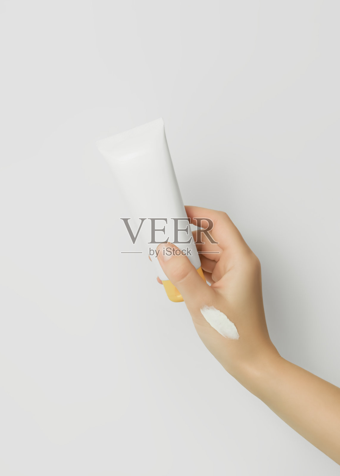 女性手拿着化妆霜样本,拿着白色的化妆霜管照片摄影图片