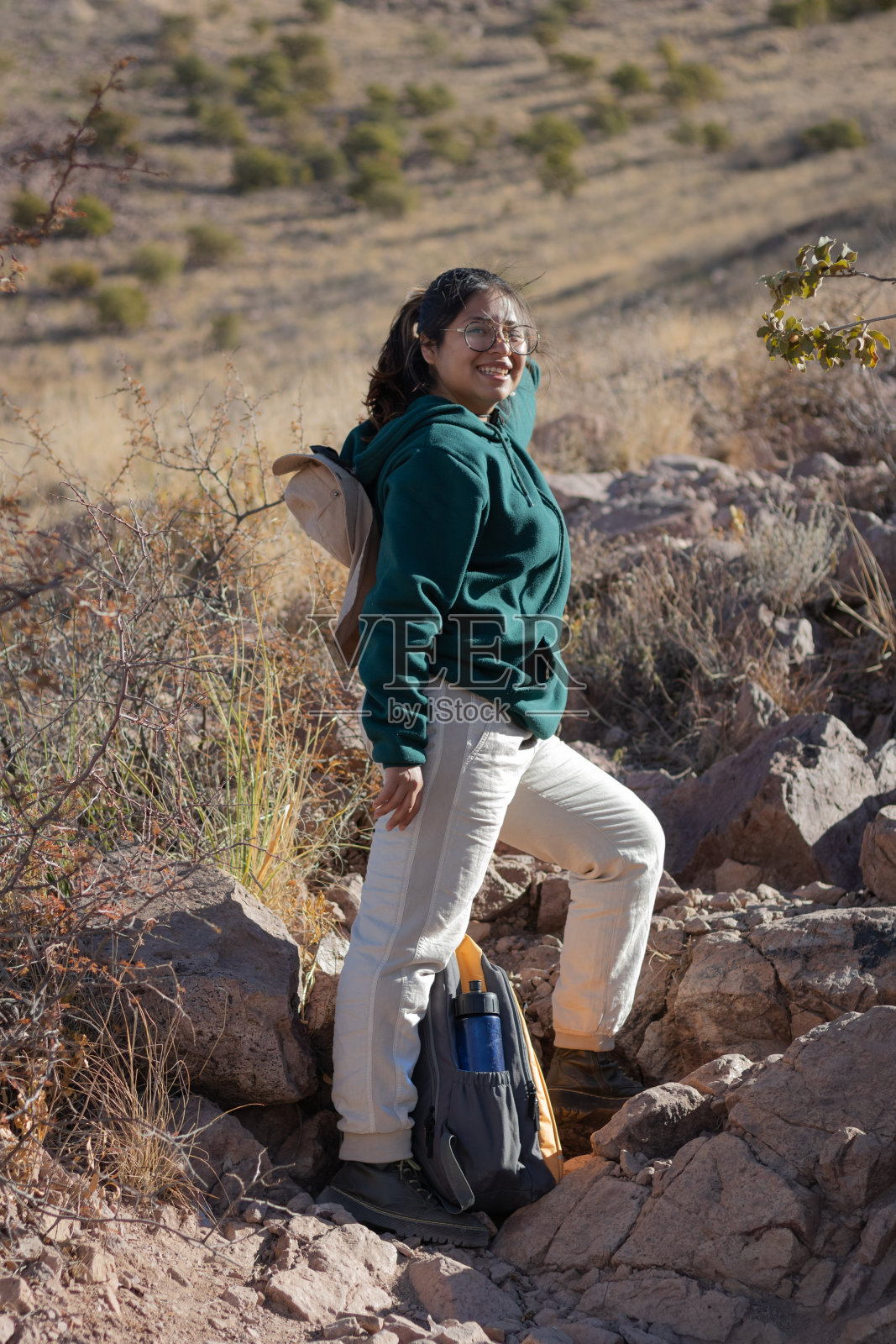 一名女子背着背包走在墨西哥山区的小路上,脸上带着微笑照片摄影图片