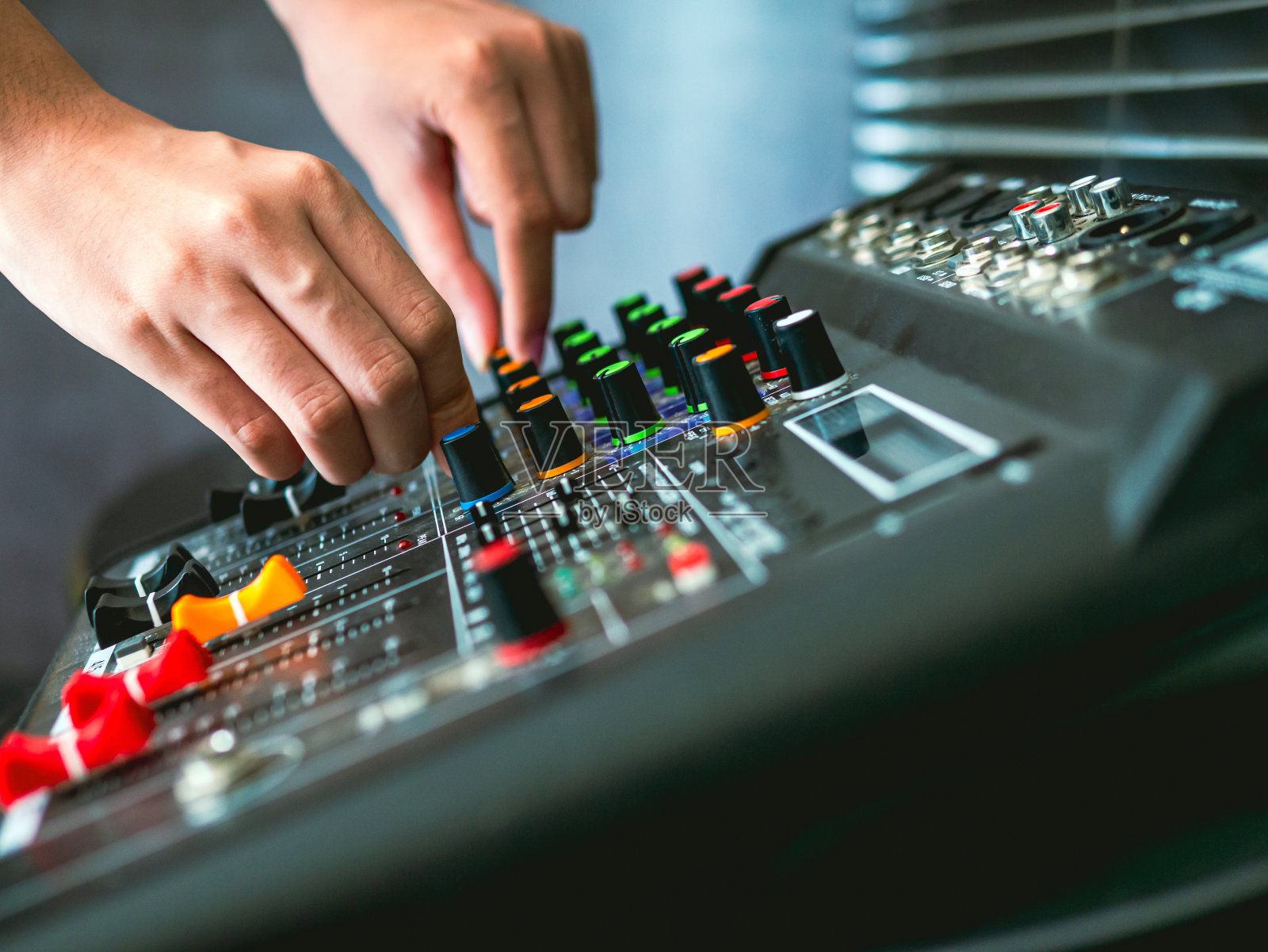 录音师在录音室、广播室、混音室调节混音器的手特写。专业的音频混音控制台,按钮,滑动器和滑块。声音检查。照片摄影图片