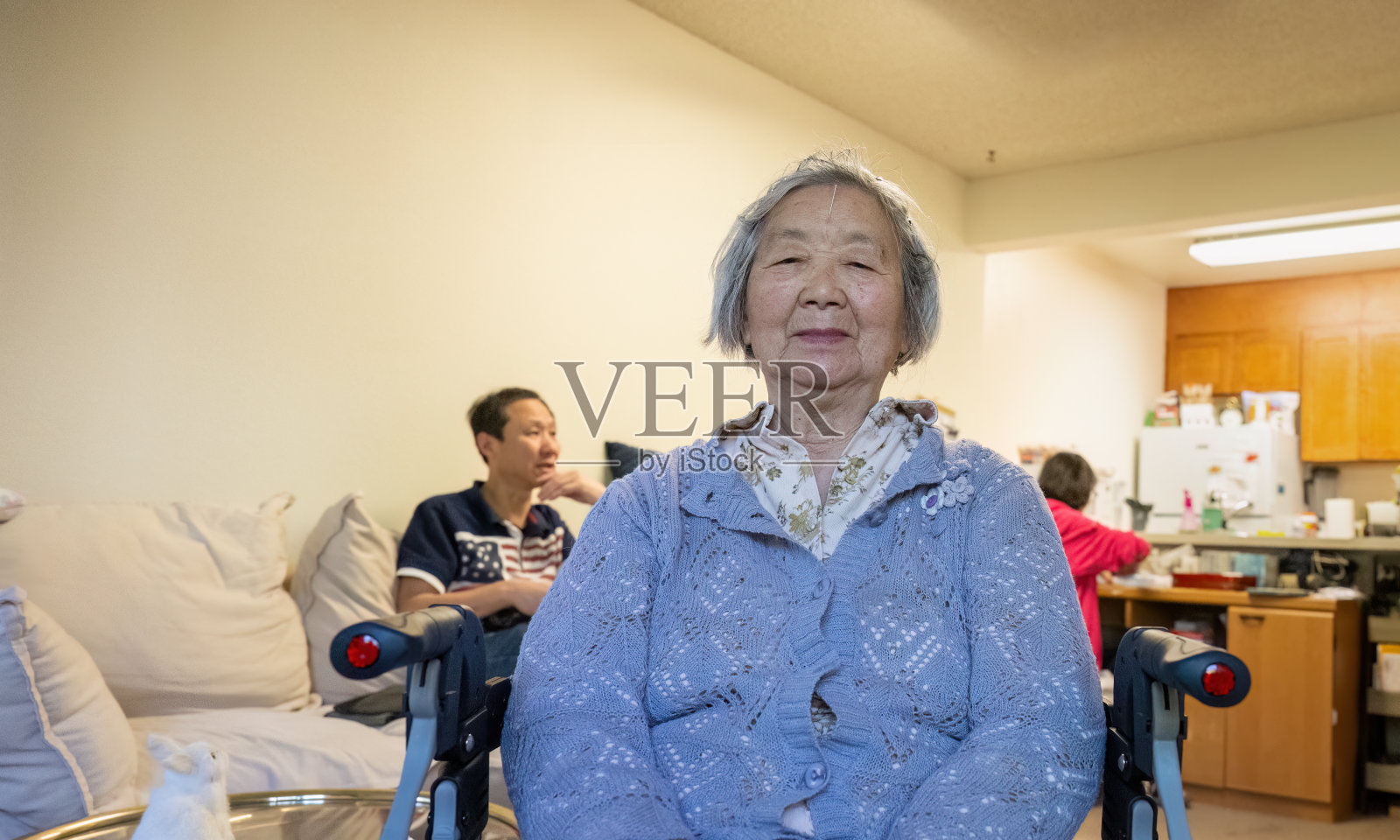 老年妇女在家里接受针灸治疗,额头上扎着针。照片摄影图片