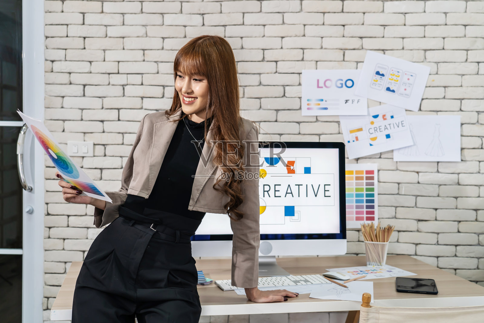 年轻的亚洲平面设计师,在充满创意的办公室工作照片摄影图片