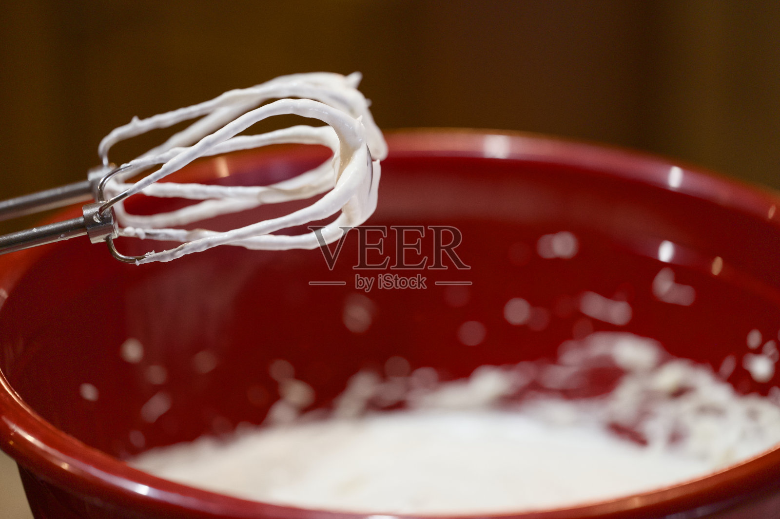 在红碗里把打蛋器和神糖的配料混合照片摄影图片