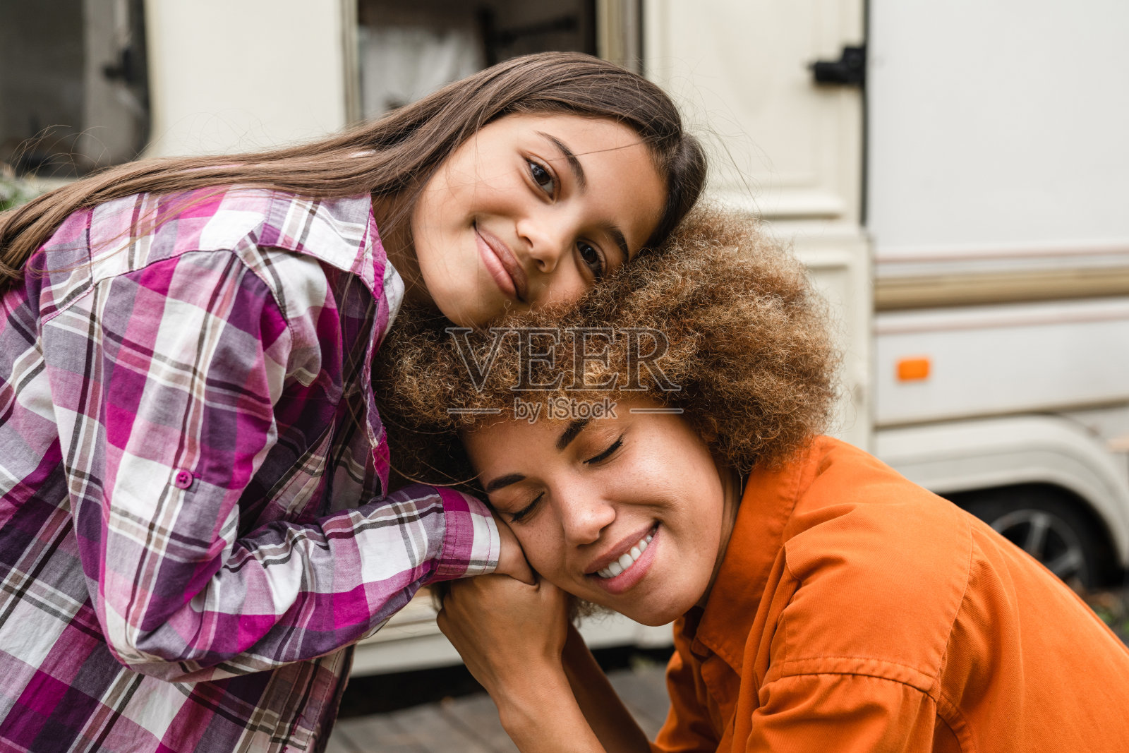 快乐的妈妈和混血女儿在房车旅行中拥抱照片摄影图片