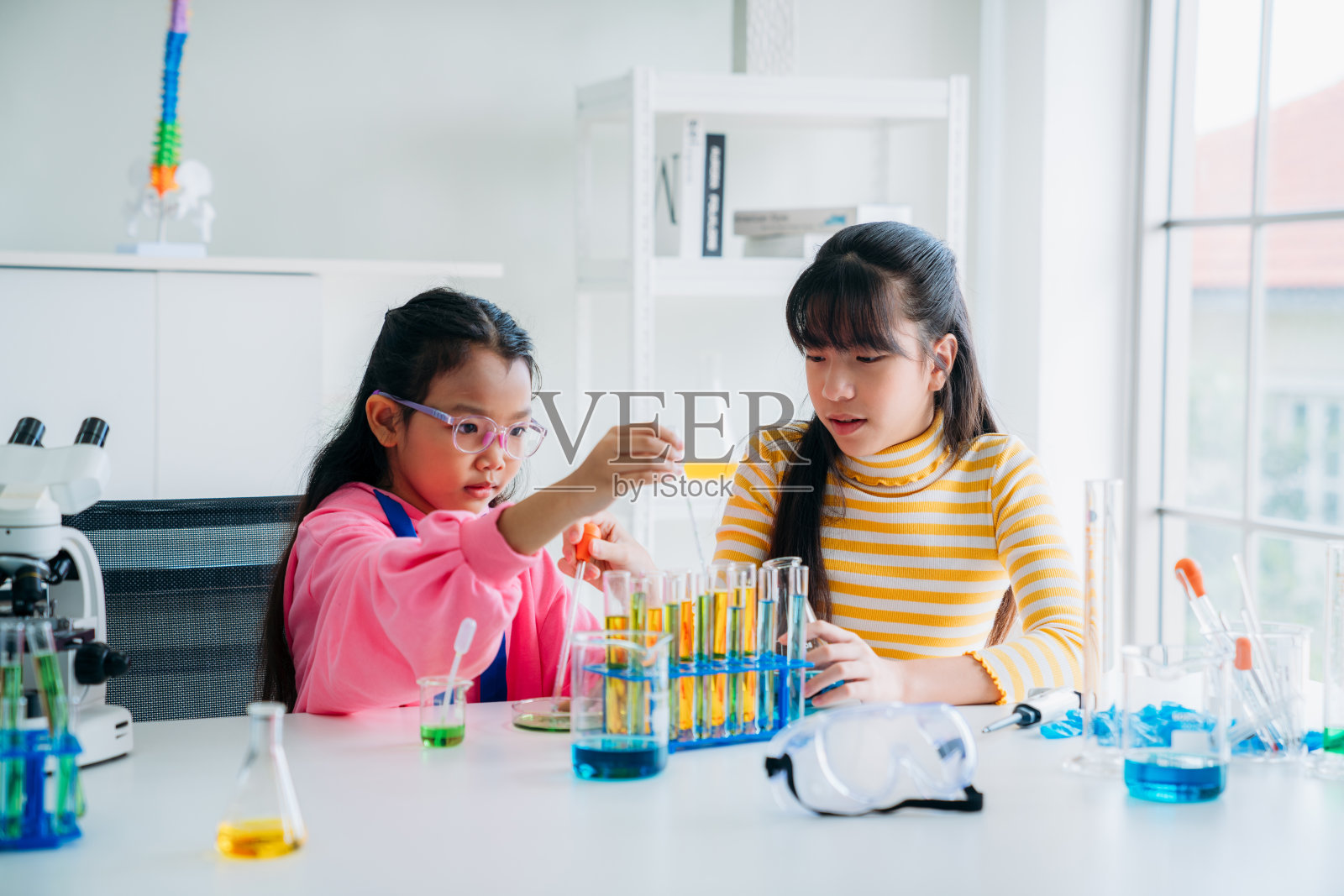 小学班的孩子们从事动手科学实验。学生通过互动和吸引人的实验发现科学的奇迹。照片摄影图片