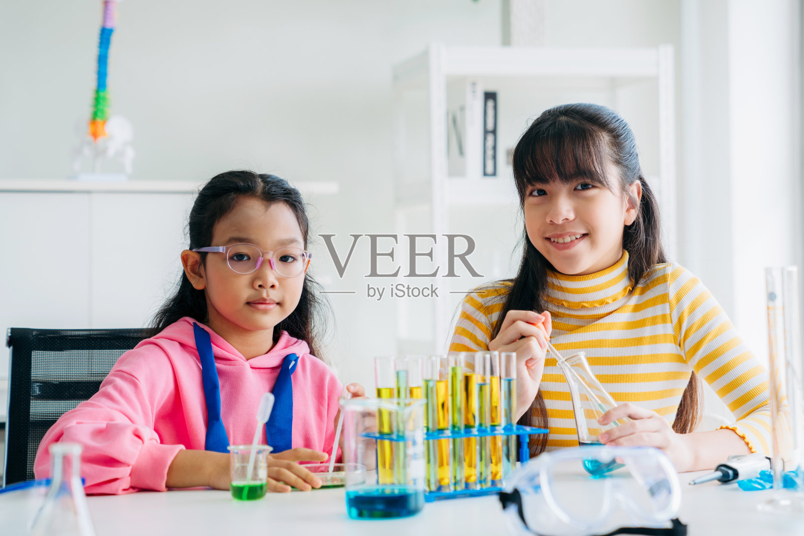 小学班的孩子们从事动手科学实验。学生通过互动和吸引人的实验发现科学的奇迹。照片摄影图片