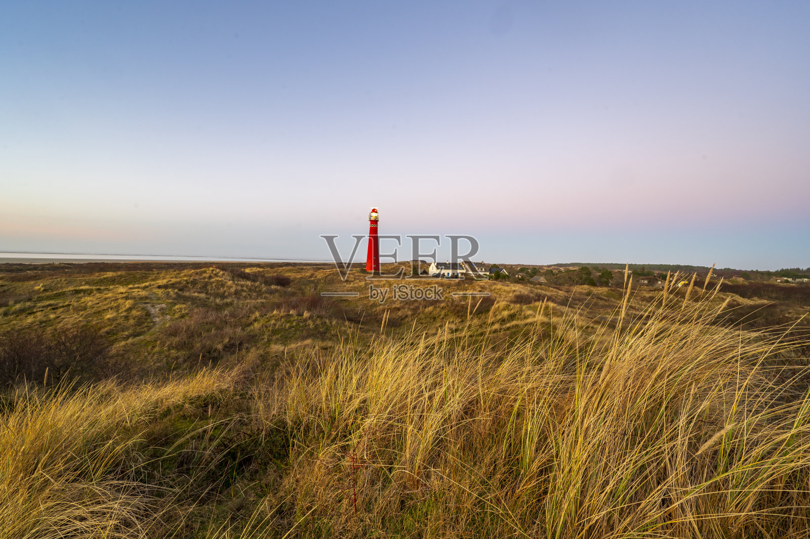 日落时分,Schiermonnikoog的沙丘全景与灯塔照片摄影图片