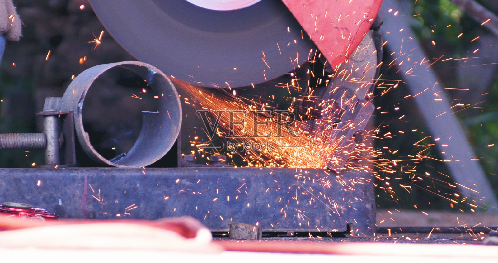 热焰焊接金属工作切割火铁车间。焊机铁金属有火花。钳工用焊机切割金属加工磨床。近距离的手在金属加工火花照片摄影图片