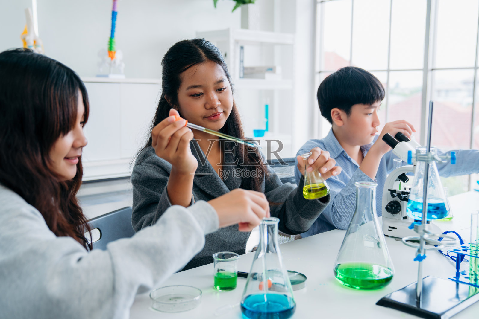 小学班的孩子们从事动手科学实验。学生通过互动和吸引人的实验发现科学的奇迹。照片摄影图片