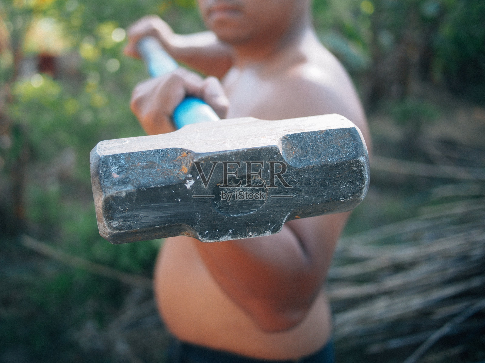 手持大锤的泰国男子照片摄影图片