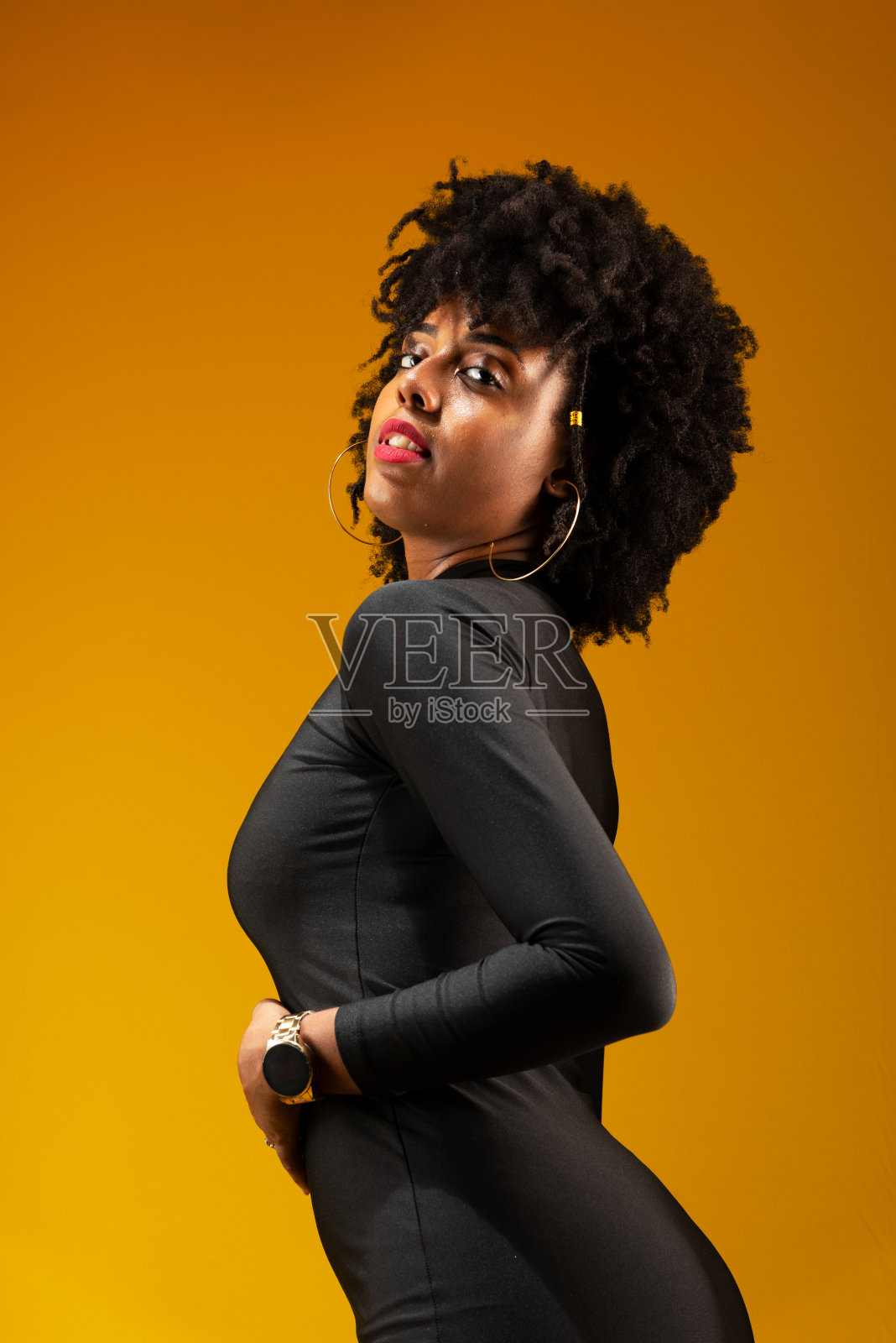 留着黑色权力发型的年轻女子,站着,穿着黑色衣服,摆姿势拍照。照片摄影图片