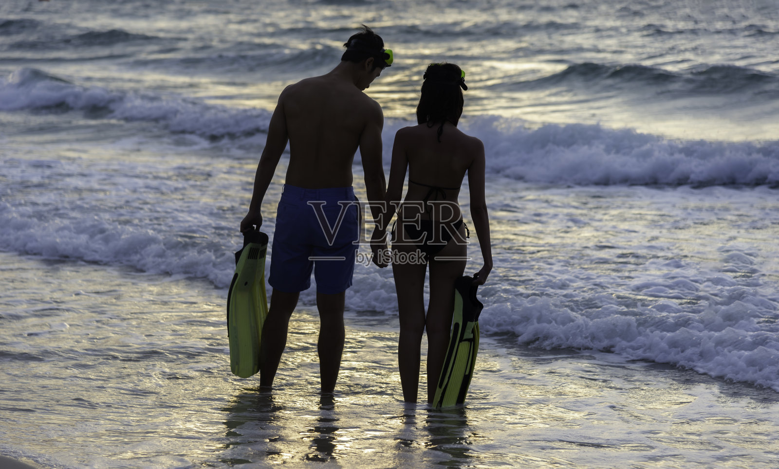 在海滩上享受快乐的假期。年轻的亚洲人,男人和女人,蜜月,爱和放松一起生活方式,夏日旅行在夕阳的背景。照片摄影图片