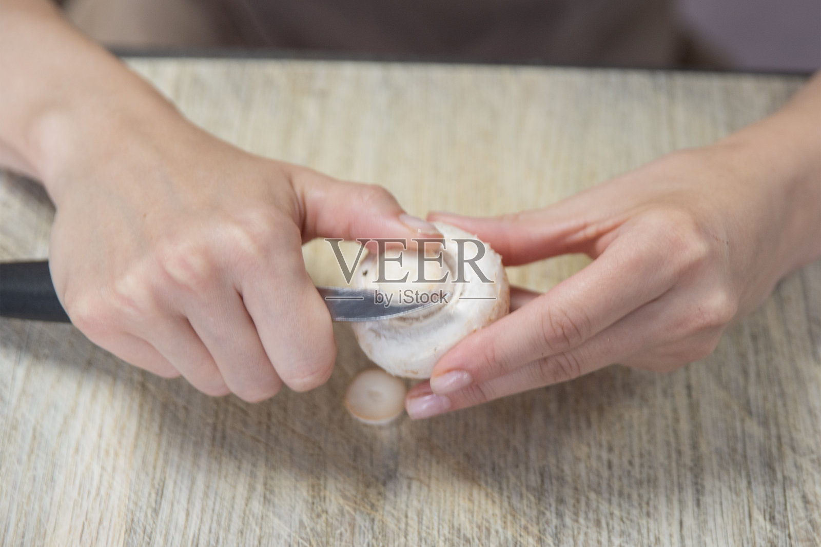 剥蘑菇的过程一个女人的手用刀剥蘑菇,特写。烹饪蘑菇。照片摄影图片
