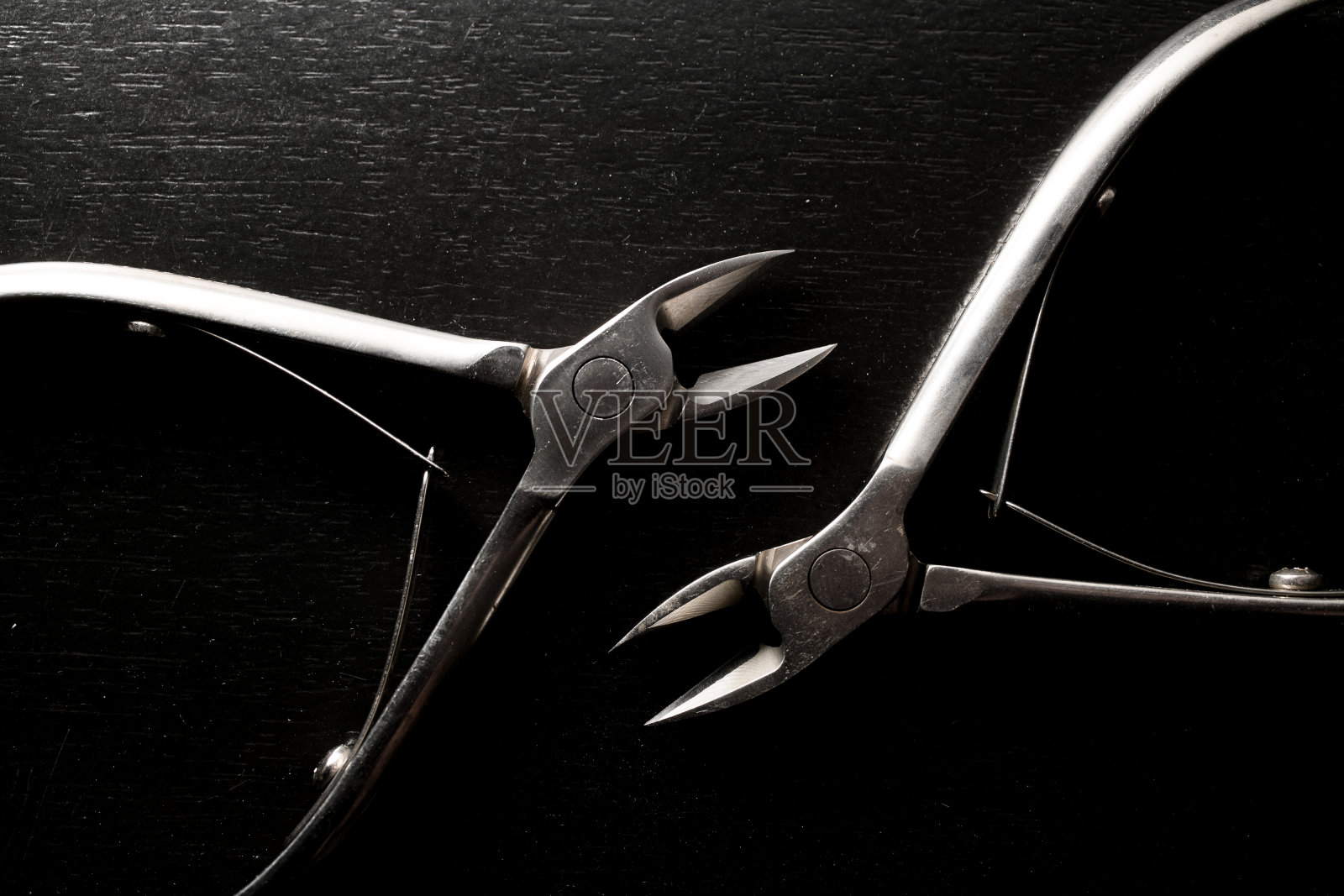 金属钢光泽角质层美甲钳工具黑色背景照片摄影图片