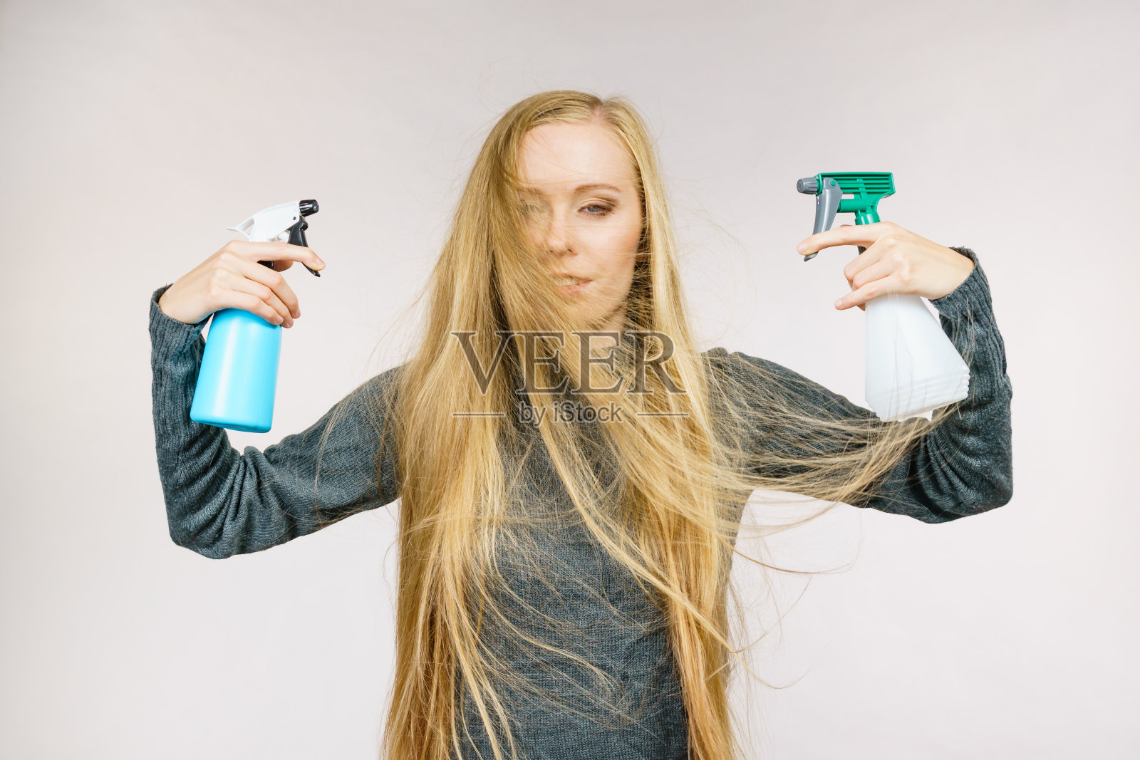 女性凌乱的长发拿着喷雾瓶照片摄影图片