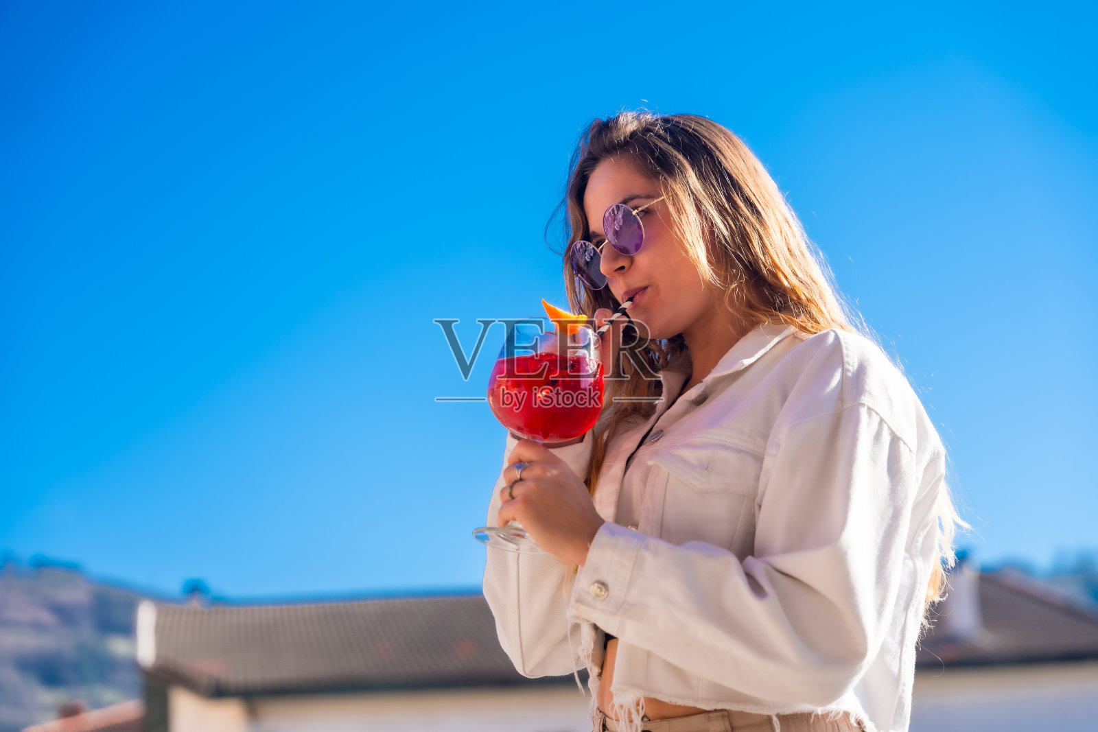 在夏日派对上喝鸡尾酒的金发女郎照片摄影图片