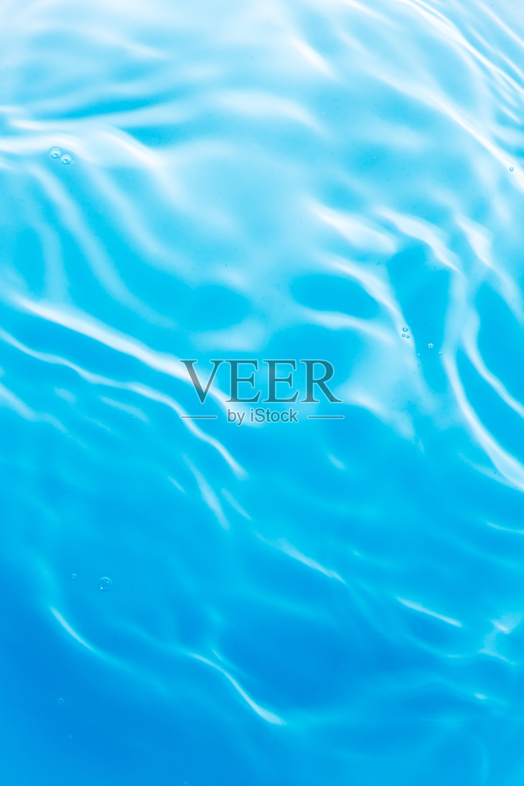 湛蓝的水面,透明的蓝色清澈的水面纹理波纹,飞溅和泡沫。抽象的自然背景水波在阳光下。化妆品保湿胶束爽肤乳。俯视图照片摄影图片