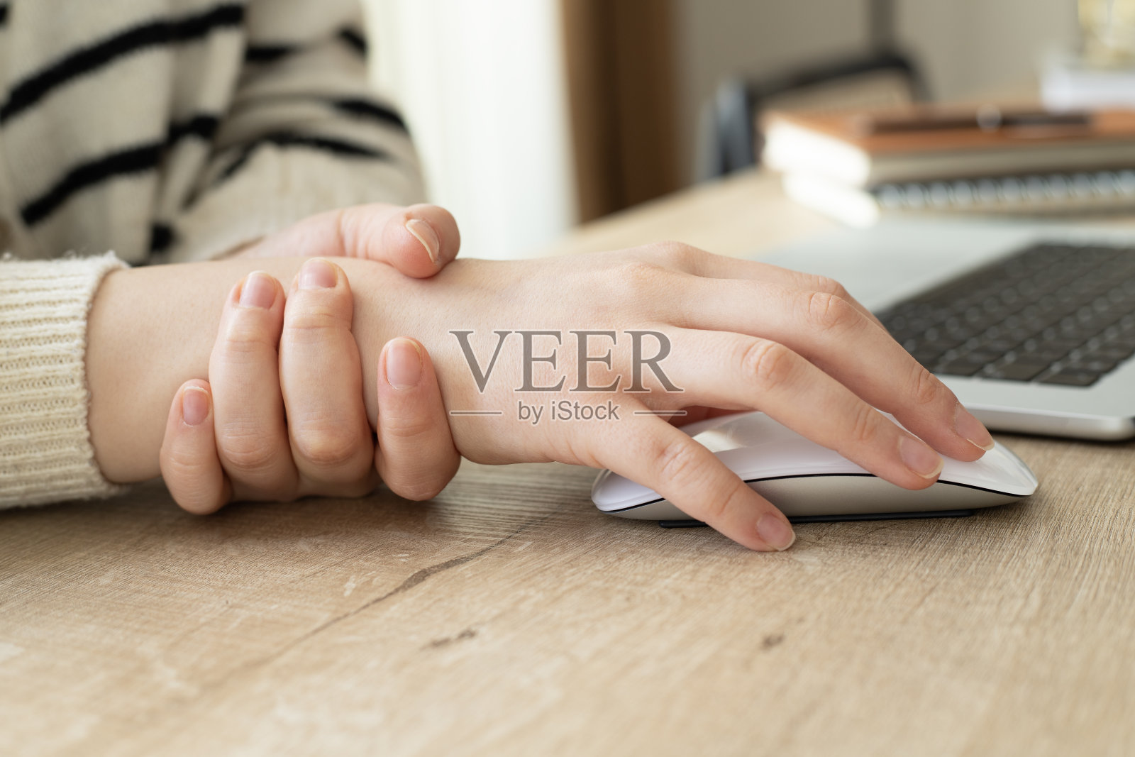 一位女士在长时间使用电脑后手指和手部疼痛。使用手提电脑时手腕疼痛,腕管综合症。照片摄影图片