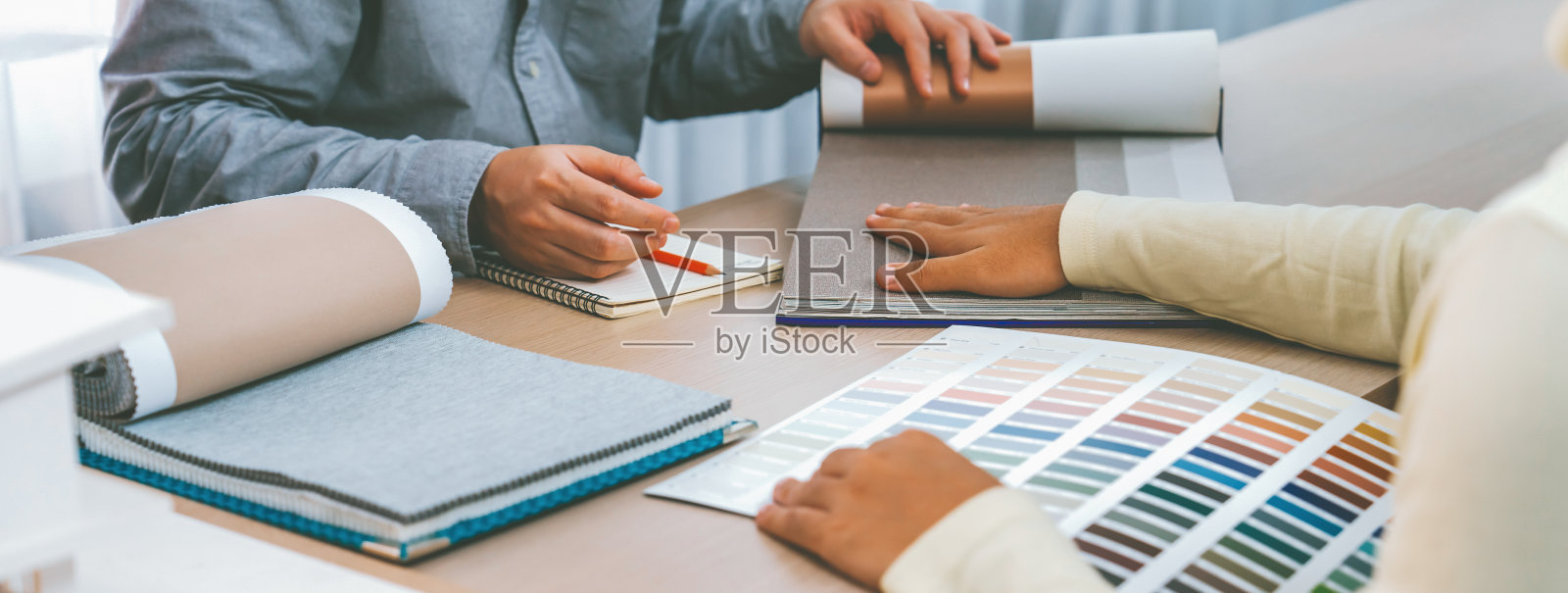 建筑师和室内设计师讨论窗帘材料。斑叶。照片摄影图片