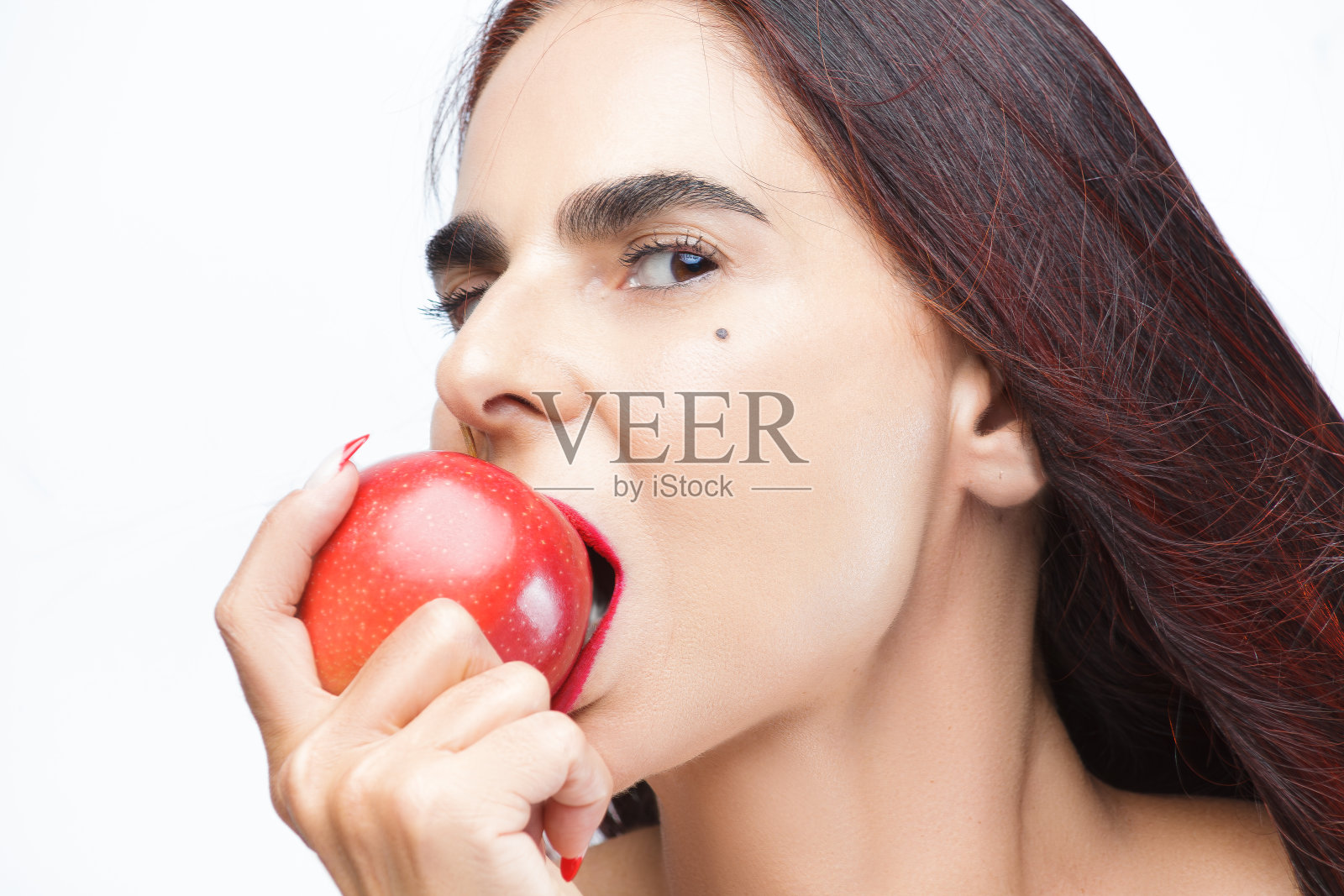 成熟与新鲜:一个咬苹果的女人的肖像照片摄影图片