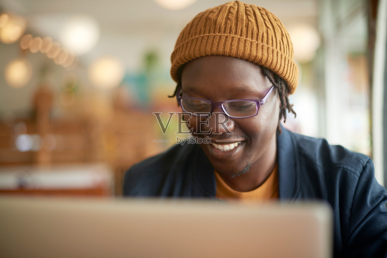 咖啡馆,微笑着和一个带着笔记本电脑的黑人,思考和创意与网站信息或文案。非洲人,记者或自由职业者,有电脑或数字应用程序,有想法和计划照片摄影图片