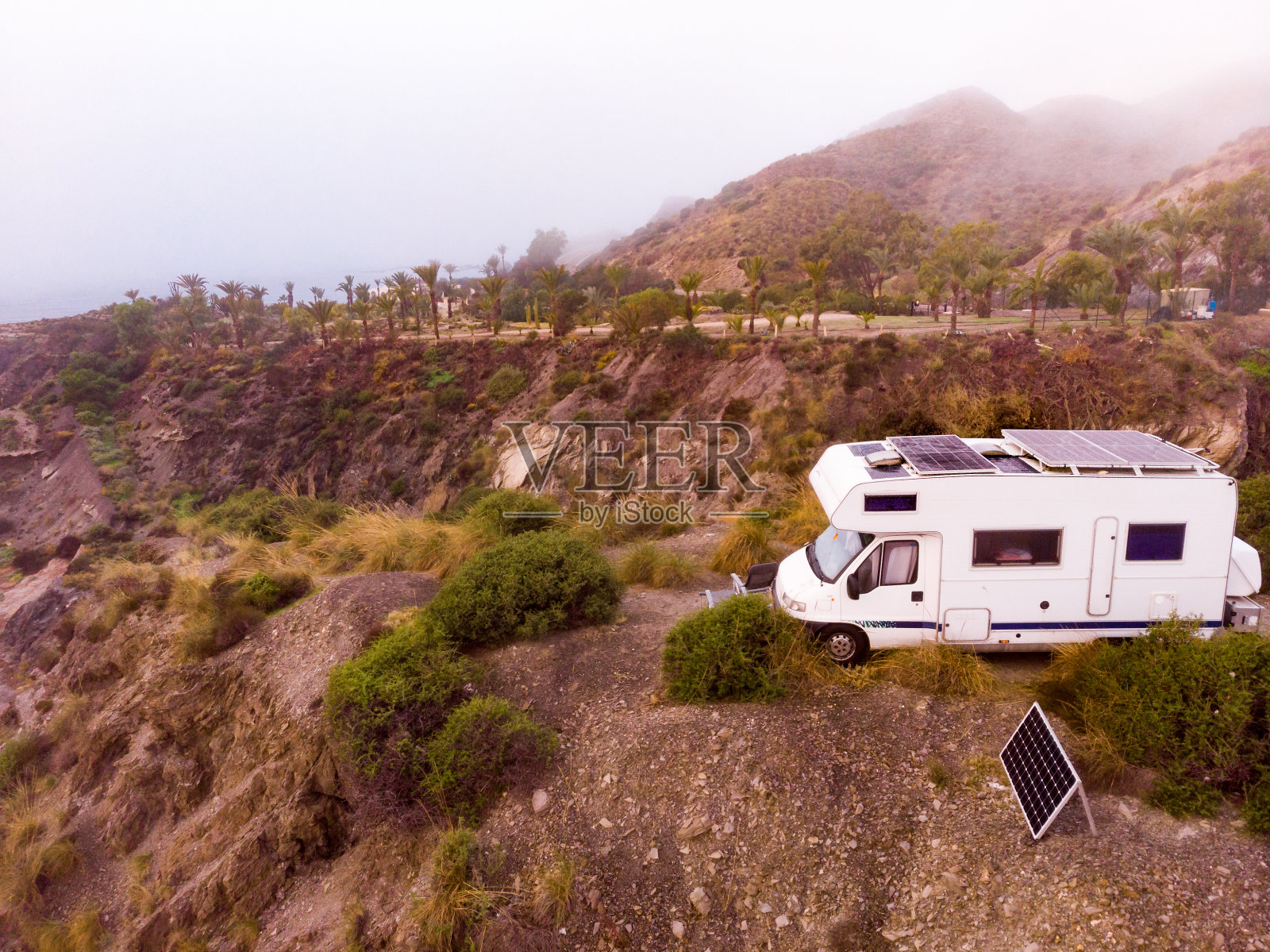 西班牙海岸,屋顶装有太阳能电池板的大篷车。鸟瞰图。照片摄影图片