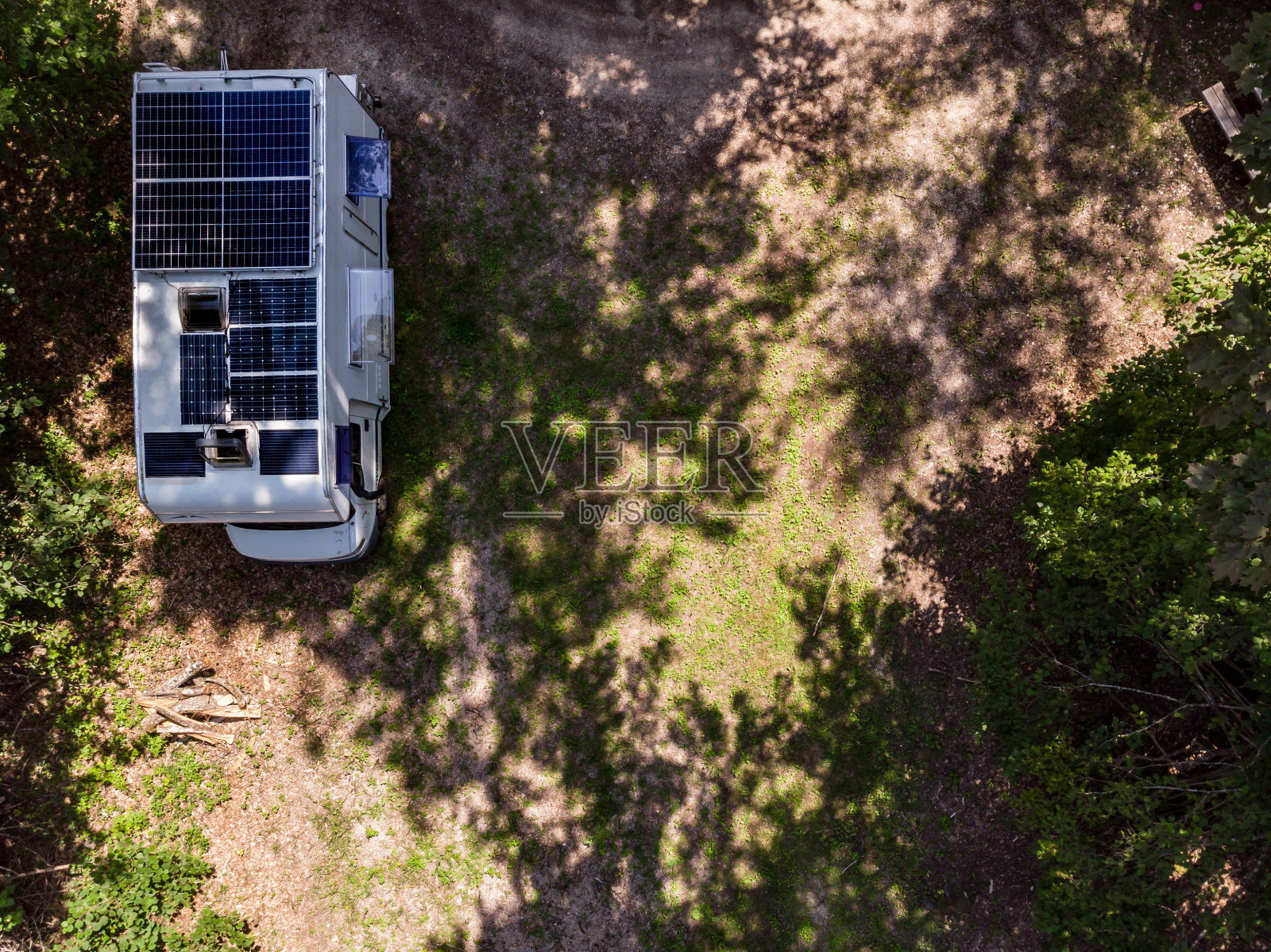 屋顶上有太阳能电池板的大篷车在大自然中露营。鸟瞰图。照片摄影图片