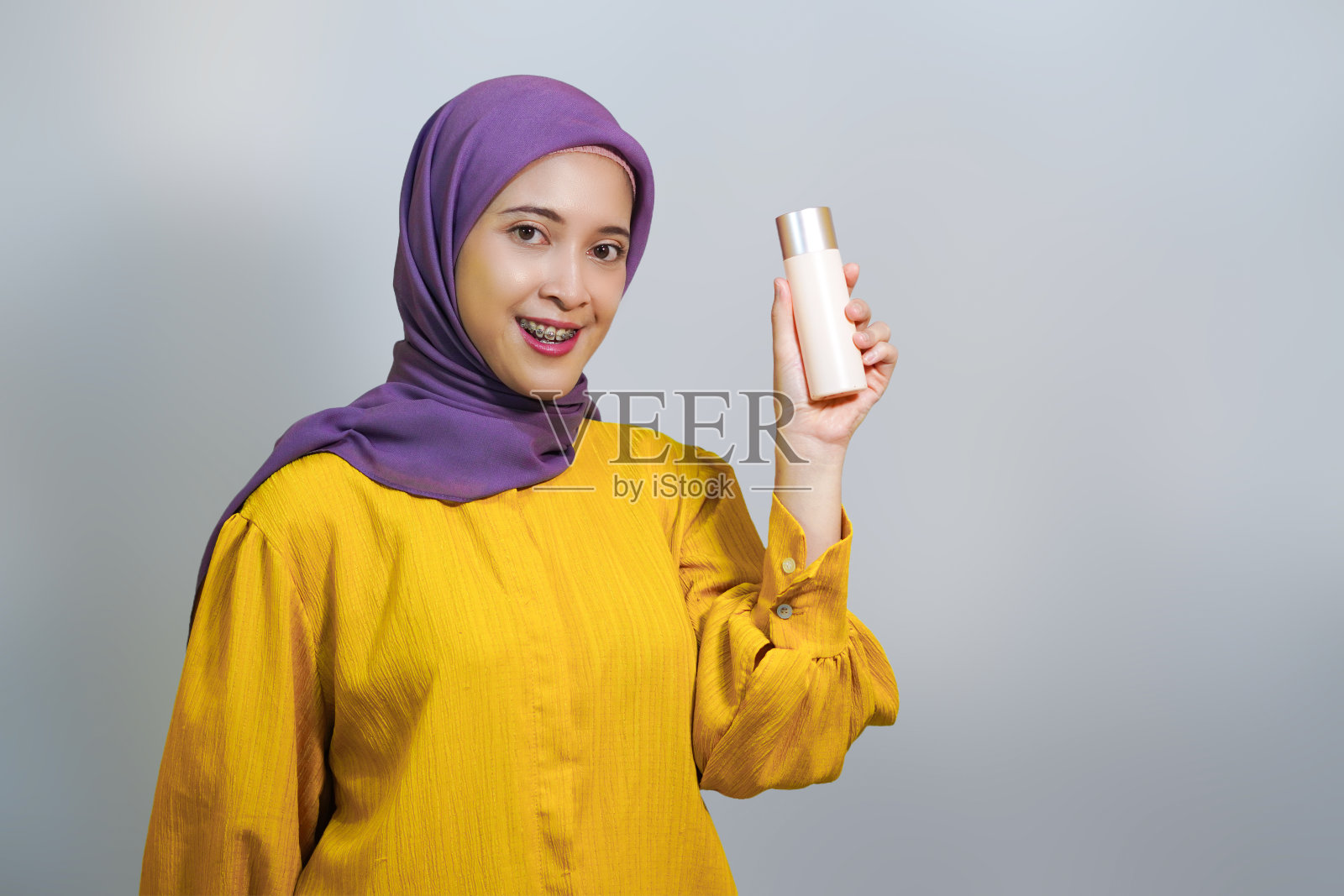 年轻的亚洲穆斯林妇女穿着黄色的衣服,孤立在白色的背景上照片摄影图片